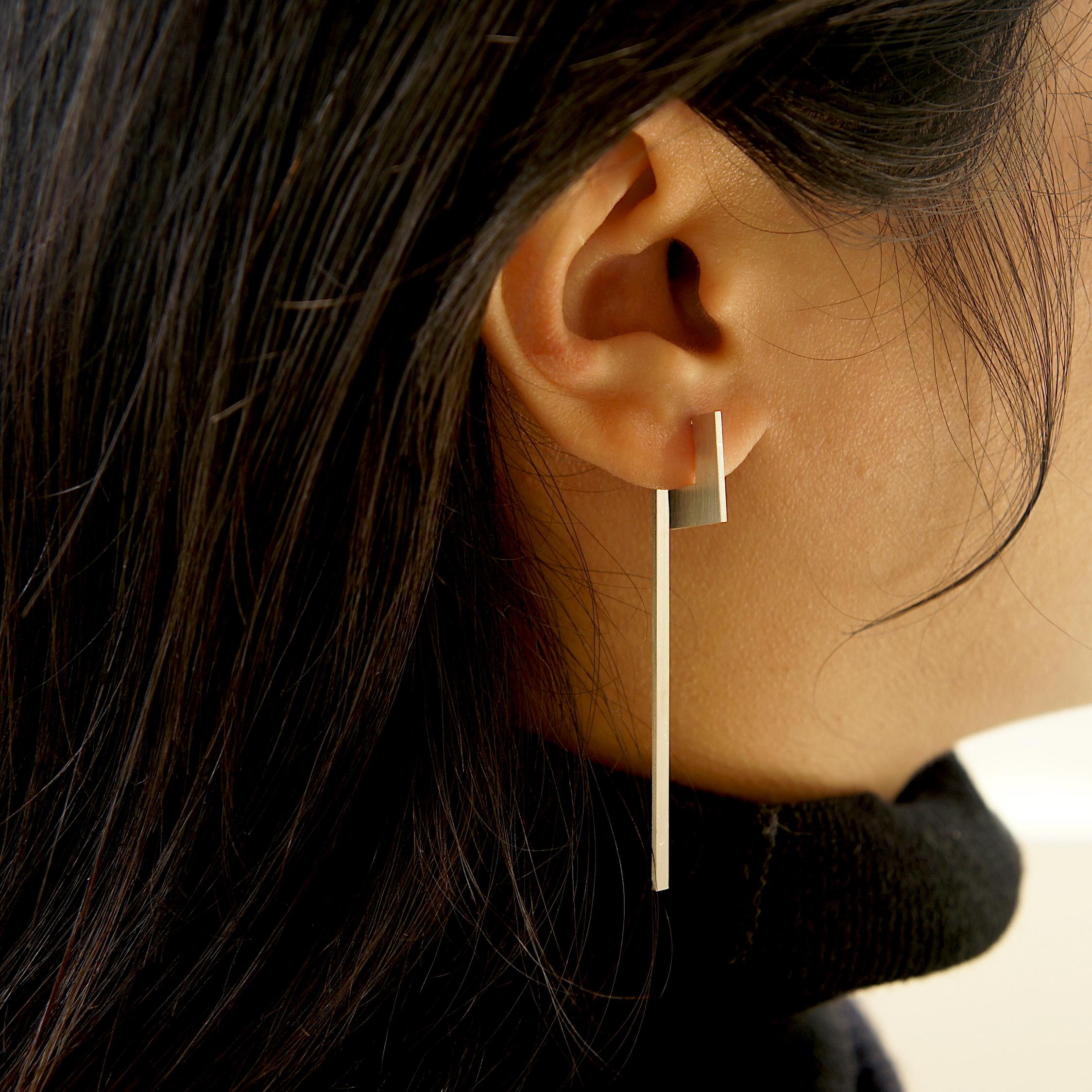 Unfinishing Line collection exudes minimalism and precision with its smooth lines and angles. 
Detailed with a perspective studs and long swinging bar structure with a matt brushed finish.  Each part of this pair of earring can be separated for