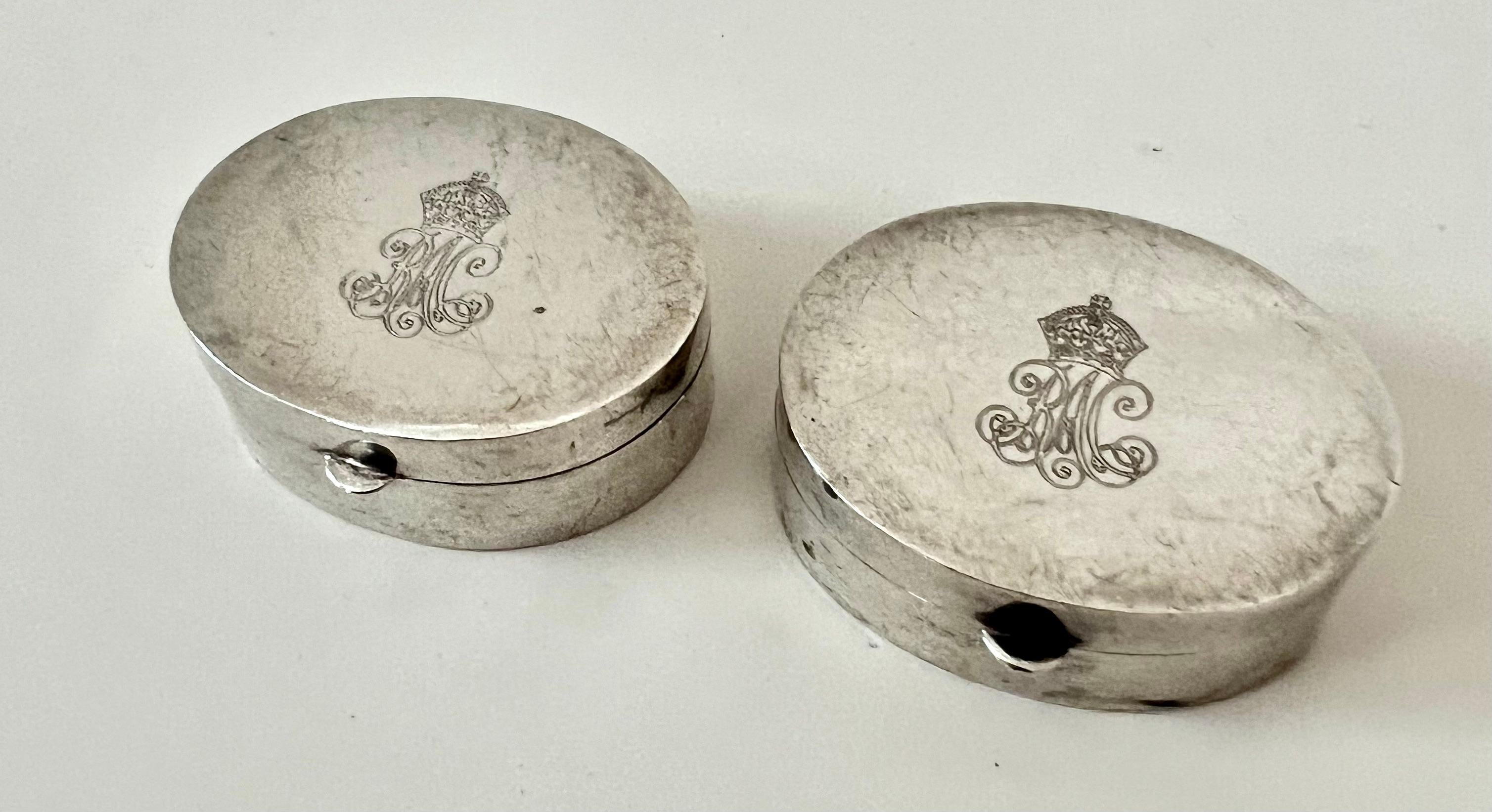 A pair of Sterling Silver Pill boxes.  The pair are in wonderful condition and have a crown with monogram on top.  While the monogram looks to be 
