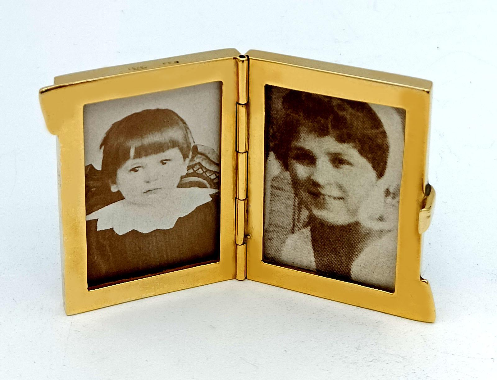 Piccolo portafoto da viaggio per 2 foto in argento 925/1000 placcato oro con smalti cotti traslucidi su guilloché e miniatura floreale dipinta a mano; linea blu all'esterno. Stile Art Nouveau inglese, primi anni del 1900. Dimensioni: 3 x 4,2 cm.