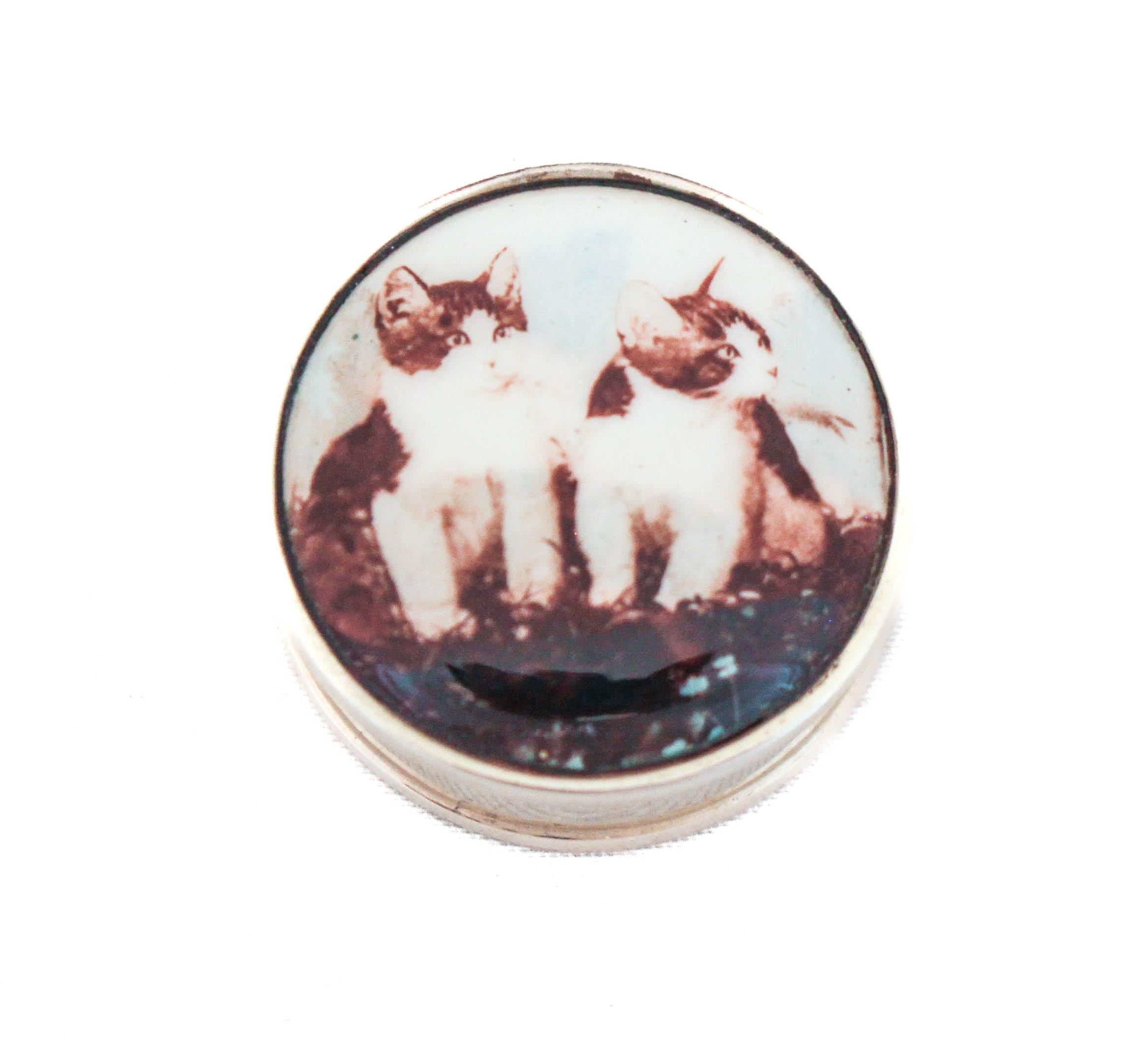 Being offered is a sterling silver pill box made in England.  It has an enamel top with two kittens on it.  The lid is attached to the box through a back hinge preventing you from losing it.  The pillbox is new and in mint condition.