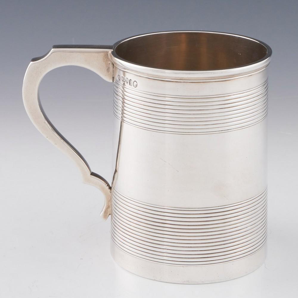 Heading : Sterling silver pint tankard
Date : Hallmarked in London in 1864 for William Evans
Period : Victoria
Origin : London, England
Decoration : Reeded sections to the top and bottom, angular scrolled handle
Size :  11.3cm height, 8.4cm