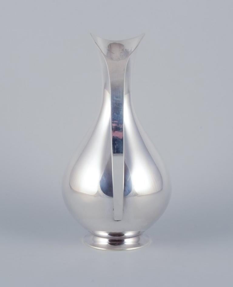 Sterling silver pitcher in a modernist and sleek design. Mid-20th C. In Excellent Condition For Sale In Copenhagen, DK