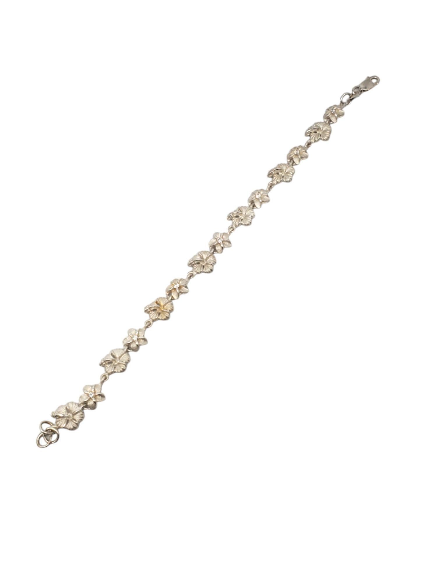 Sterling Silver Plumeria Flower Link Bracelet -

This lovely link bracelet features Plumeria flowers set in sterling silver with CZ accents.

Size: 7 in. in length

8.2mm at widest

Stamped: 925

Weigh: 6.09 dwt / 9.44 g

Very good condition,