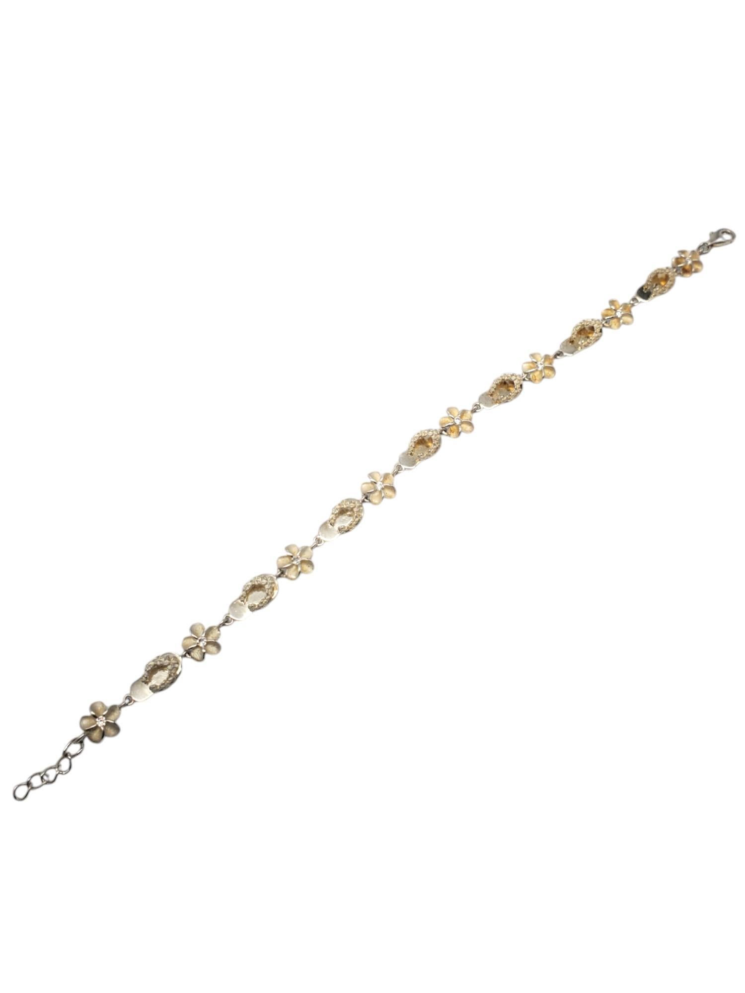 Sterling Silver Plumeria Flowers & Flip Flops CZ Link Bracelet -

This beautiful bracelet features alternating plumeria flower with 8 round CZ center stones & flip flop sandal set in sterling silver with a lobster claw clasp.

Size: 8 in in