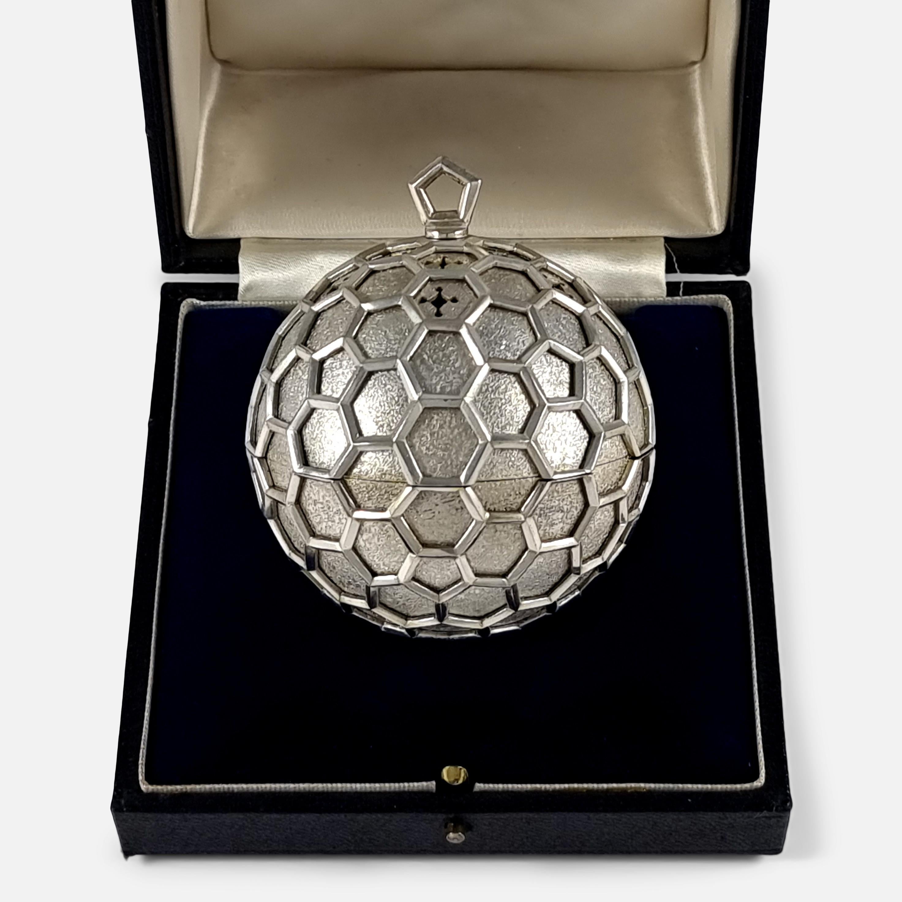 A cased Elizabeth II sterling silver Pomander designed by Anthony Elson RCA, for Garrard & Co Ltd. The Pomander is of globular form, the textured ground with decorative piercing, pierced honeycomb overlay, and a gilded interior.

The term
