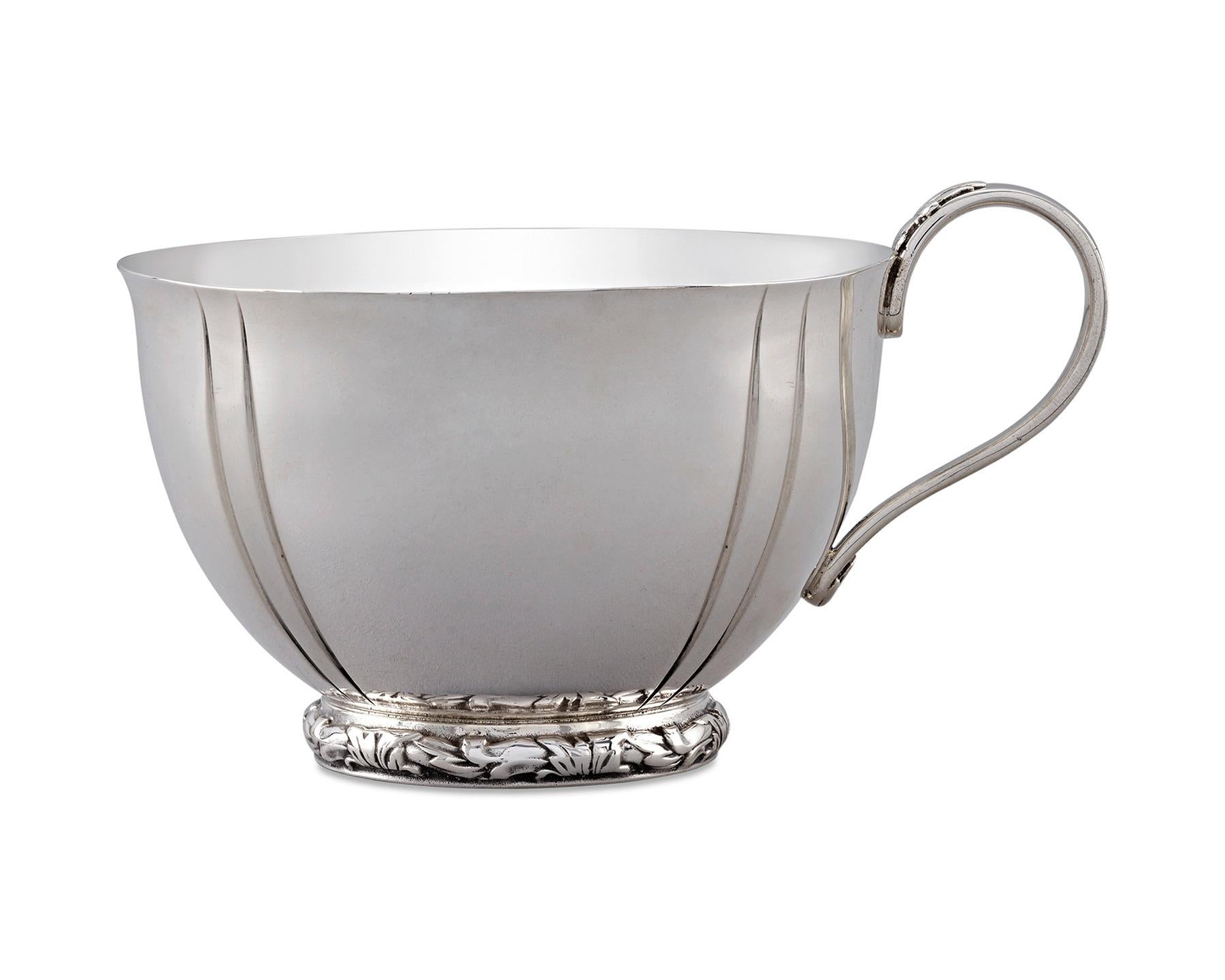 This exceptional set of 12 punch cups by Tiffany & Co. reflects the famed American firm's eye for style. Crafted from sterling silver, the masterfully designed cups feature the perfect amount of detail. A stylized foliate motif encircles the base,