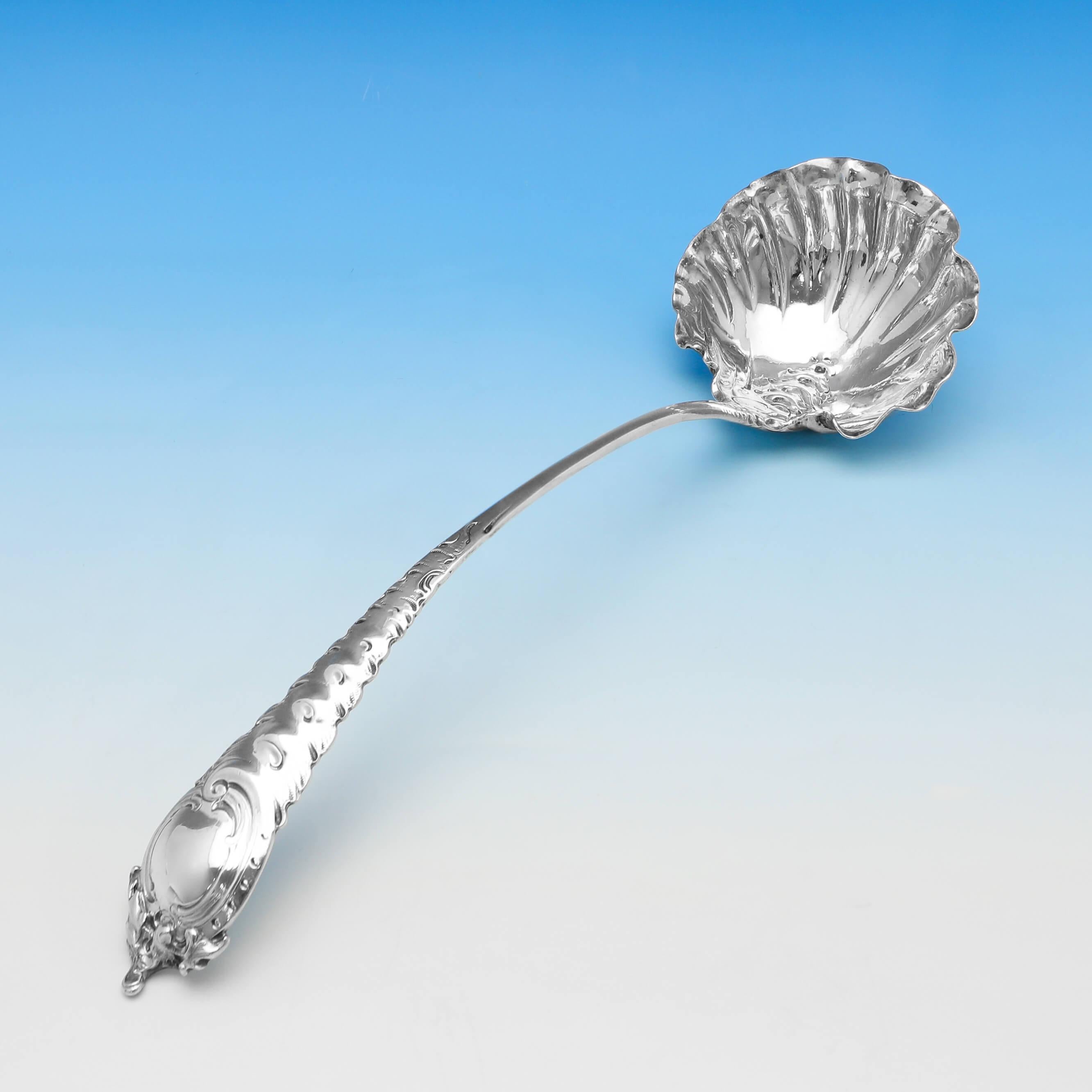 Hallmarked in London in 1756 by Ebeneezer Coker, this striking, George II, antique sterling silver punch ladle, is in the Rococo taste. With an ornate handle and shaped bowl. The punch ladle measures 13