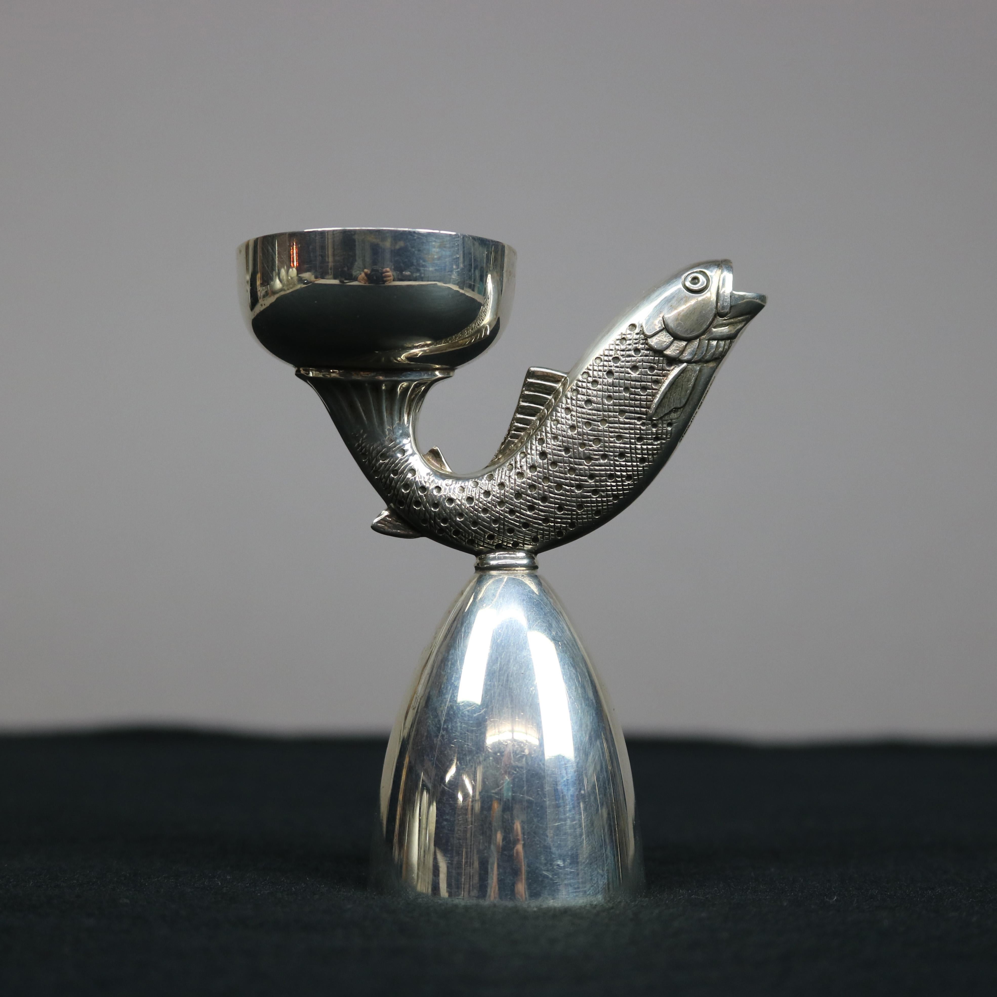 A sterling silver bar back jigger by R. Blackinton & Co. offers shot cups and central fish (rainbow trout), stamped as photographed, 20th century

Measures - 4.5''H x 3.5''W x 3.5''D.