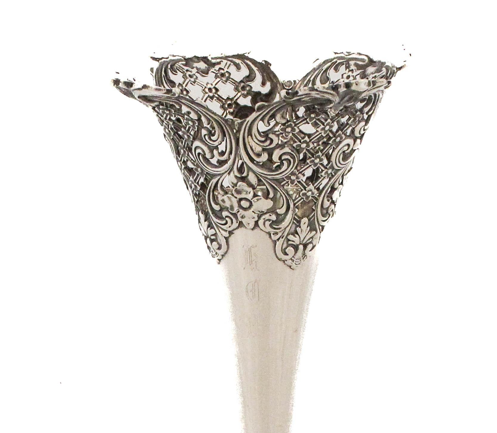 Questo straordinario vaso in argento sterling da 12 pollici di Redlich & Company è un magnifico esempio di artigianato americano dell'inizio del XX secolo. La forma alta e svasata è sostenuta da una base ornata e ricca di dettagli con un motivo
