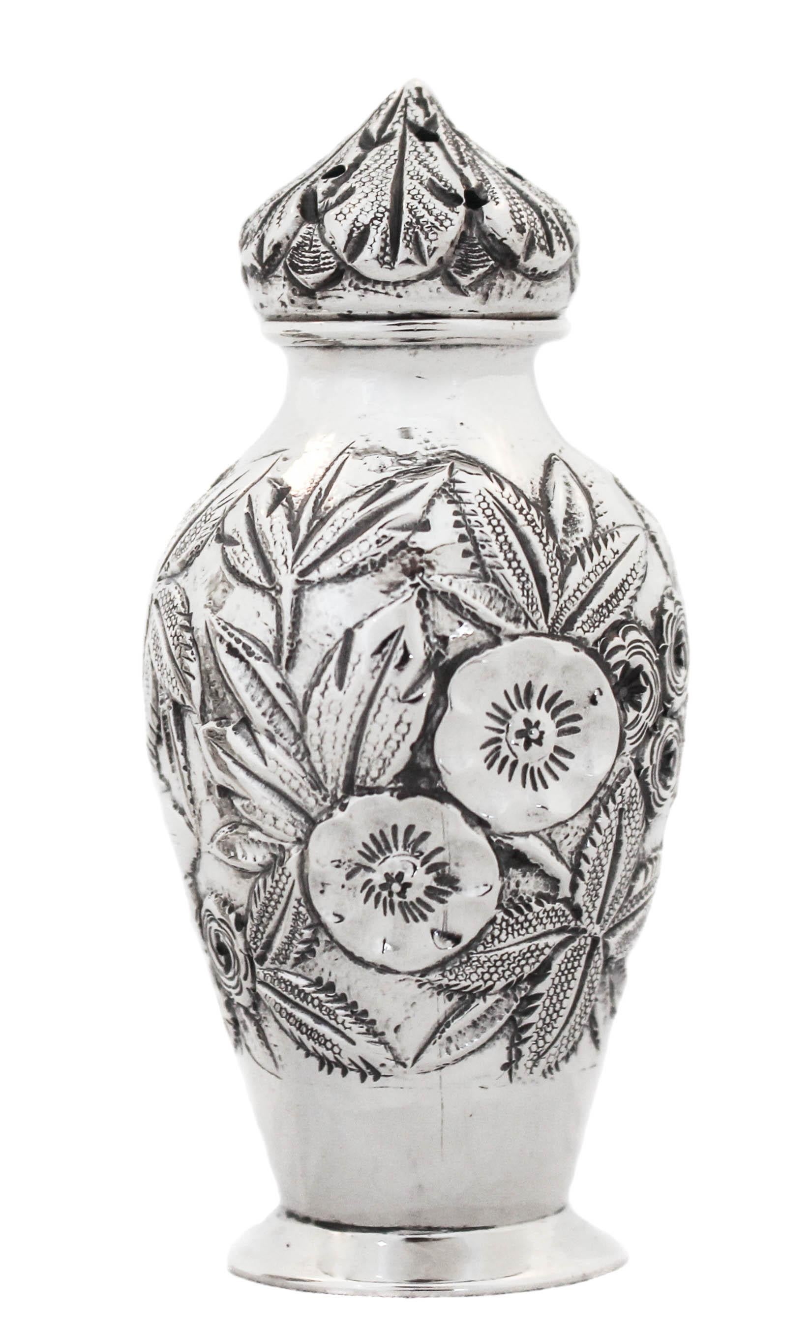 A pair of sterling silver salt shakers in the “Repousse” pattern by S. Kirk & Sons of Baltimore. “Repousse” is synonymous with S. Kirk & Sons; it is there most famous and celebrated pattern. Clusters of flowers and leaves cover the entire shaker and