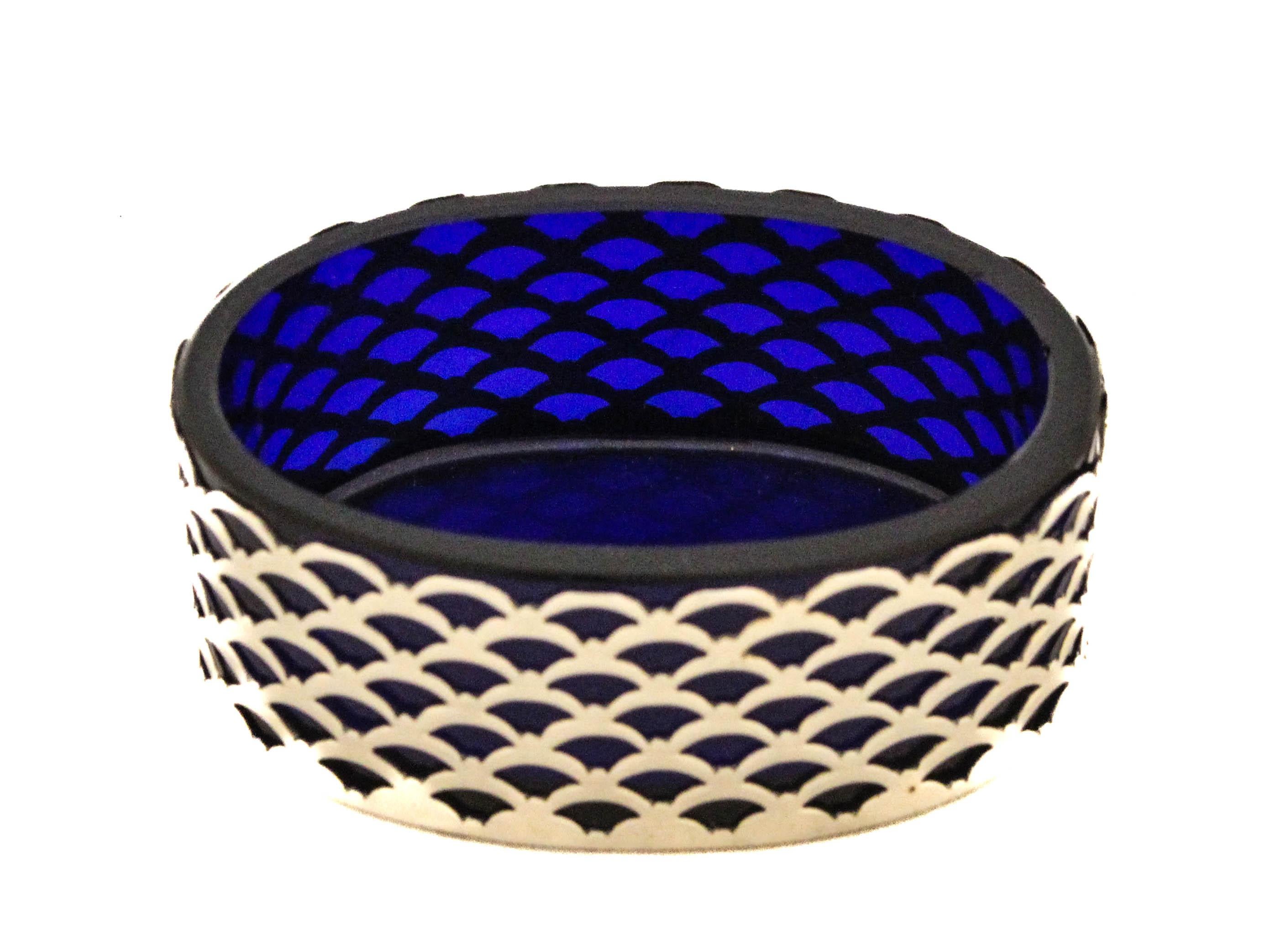 This striking oval sterling silver salt cellar by International Silver showcases a refined interplay of materials and form, with a deeply saturated cobalt glass liner encased within a finely crafted reticulated sterling body. The outer silver casing