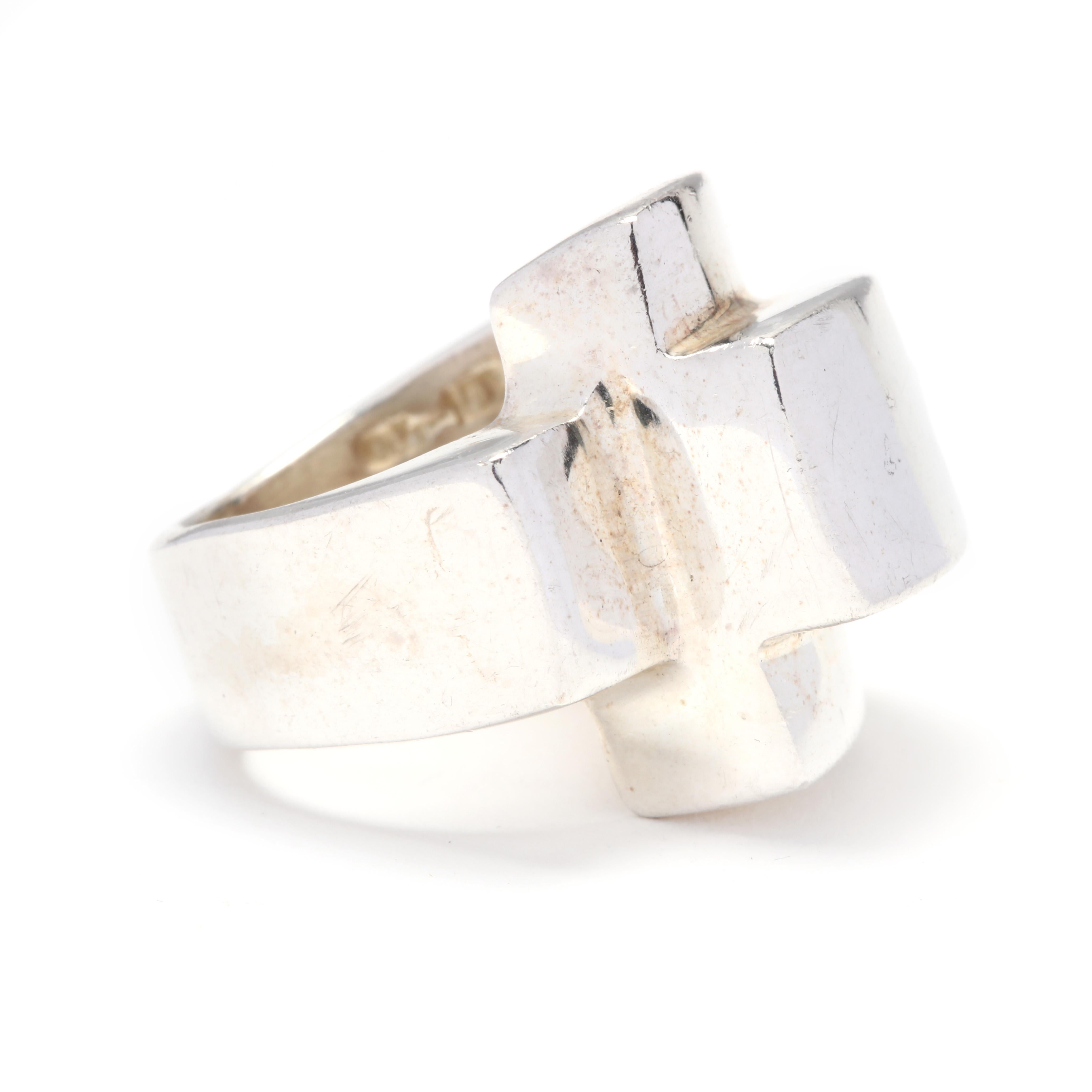 A sterling silver ridged statement ring. A domed ring with a rectangular ridged crossover motif and a tapered shank.

Ring Size 6.25

Length: 13/16 in.

19.35 grams

* Please note that this is a vintage item and may show signs of wear. It has been