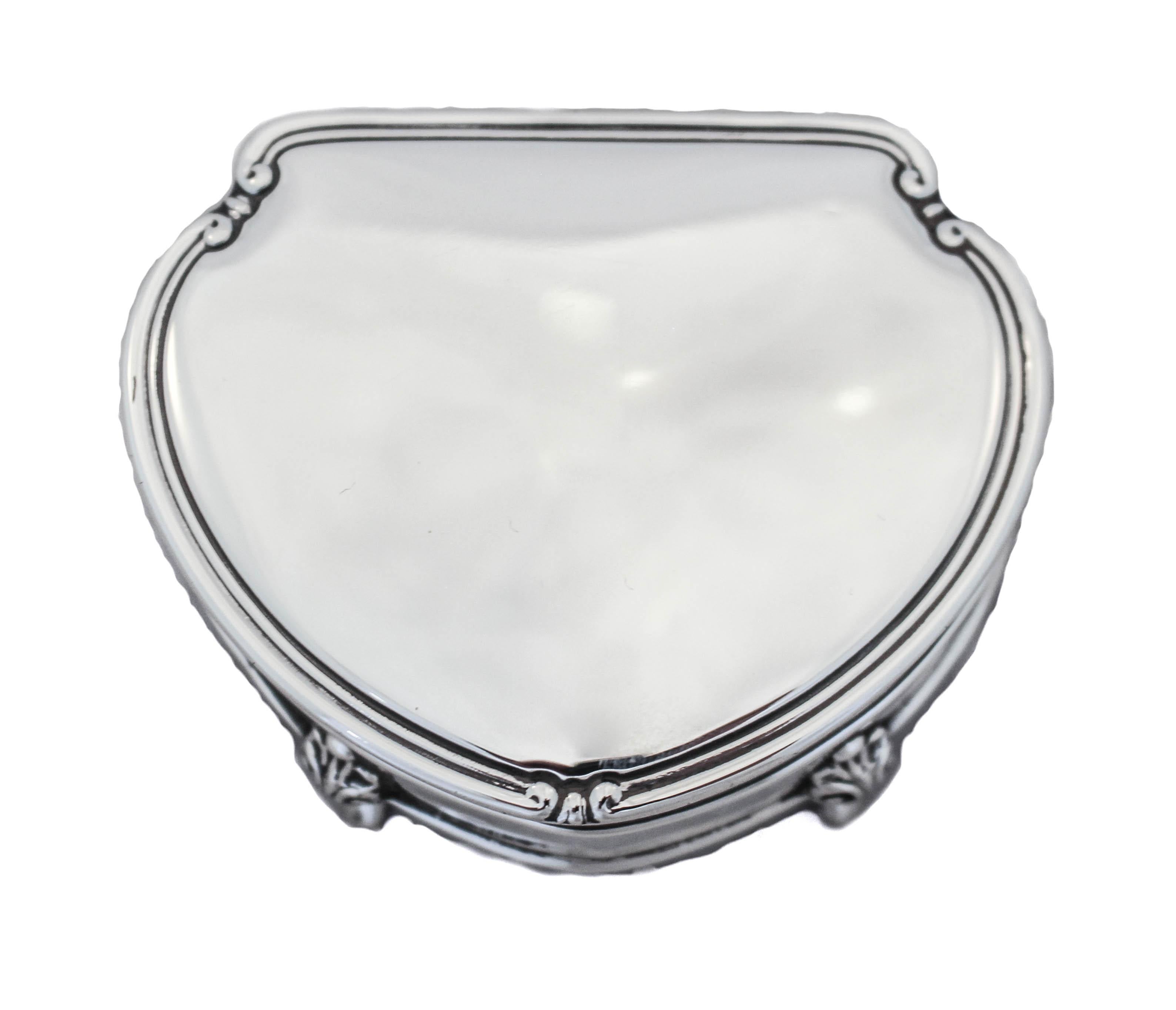 This sterling silver ring box was made in England in the late 19th century. It stands on 4 legs so it’s propped off the surface. The lining is original to the piece because we chose to maintain its authenticity. The lid open towards the back and is
