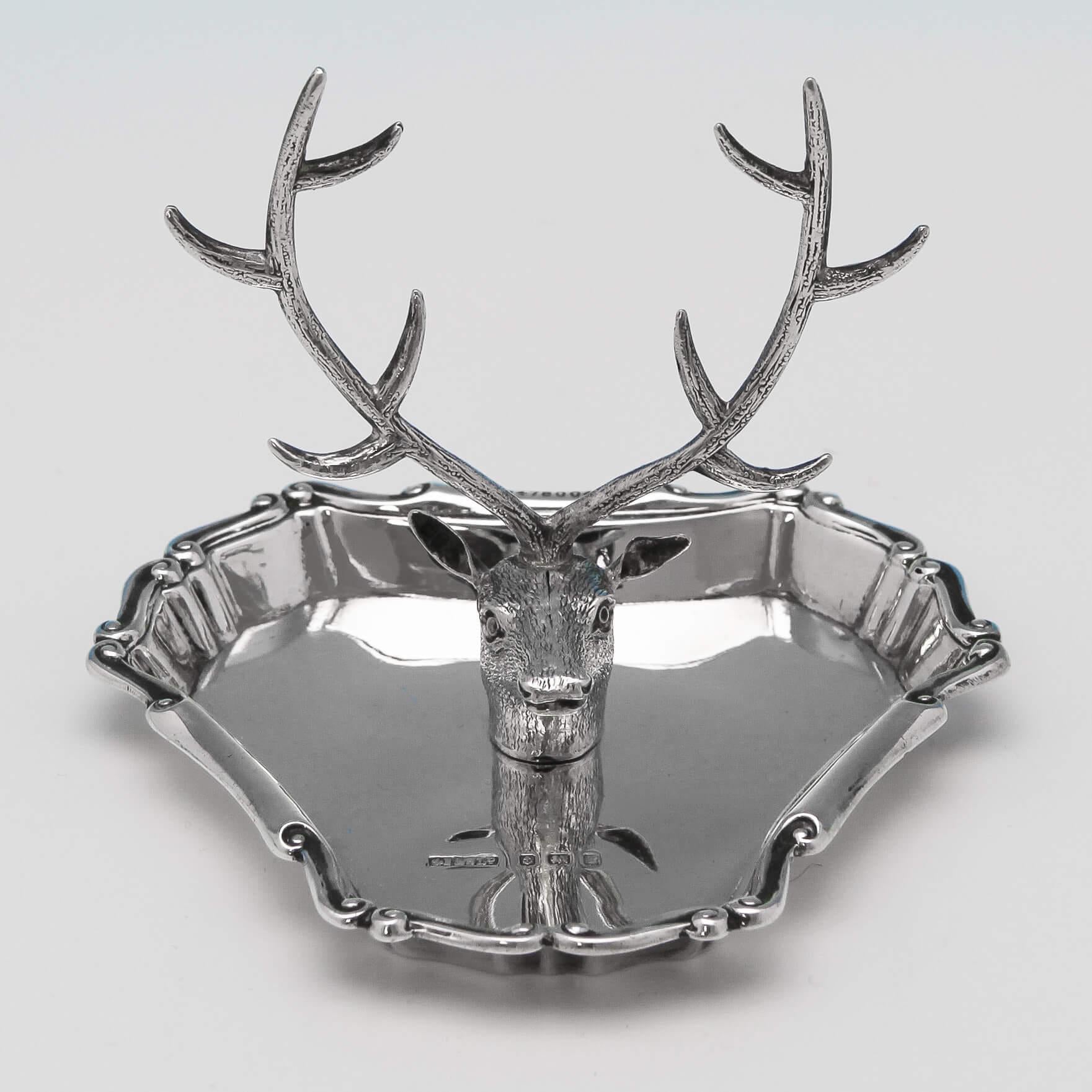 Hallmarked in Birmingham, 1905 by Stokes & Ireland, this novel Edwardian, Antique Sterling Silver Ring Tree, suspends rings on a stag's antlers. The dish itself, has a shaped scroll border. This ring tree is 2.75