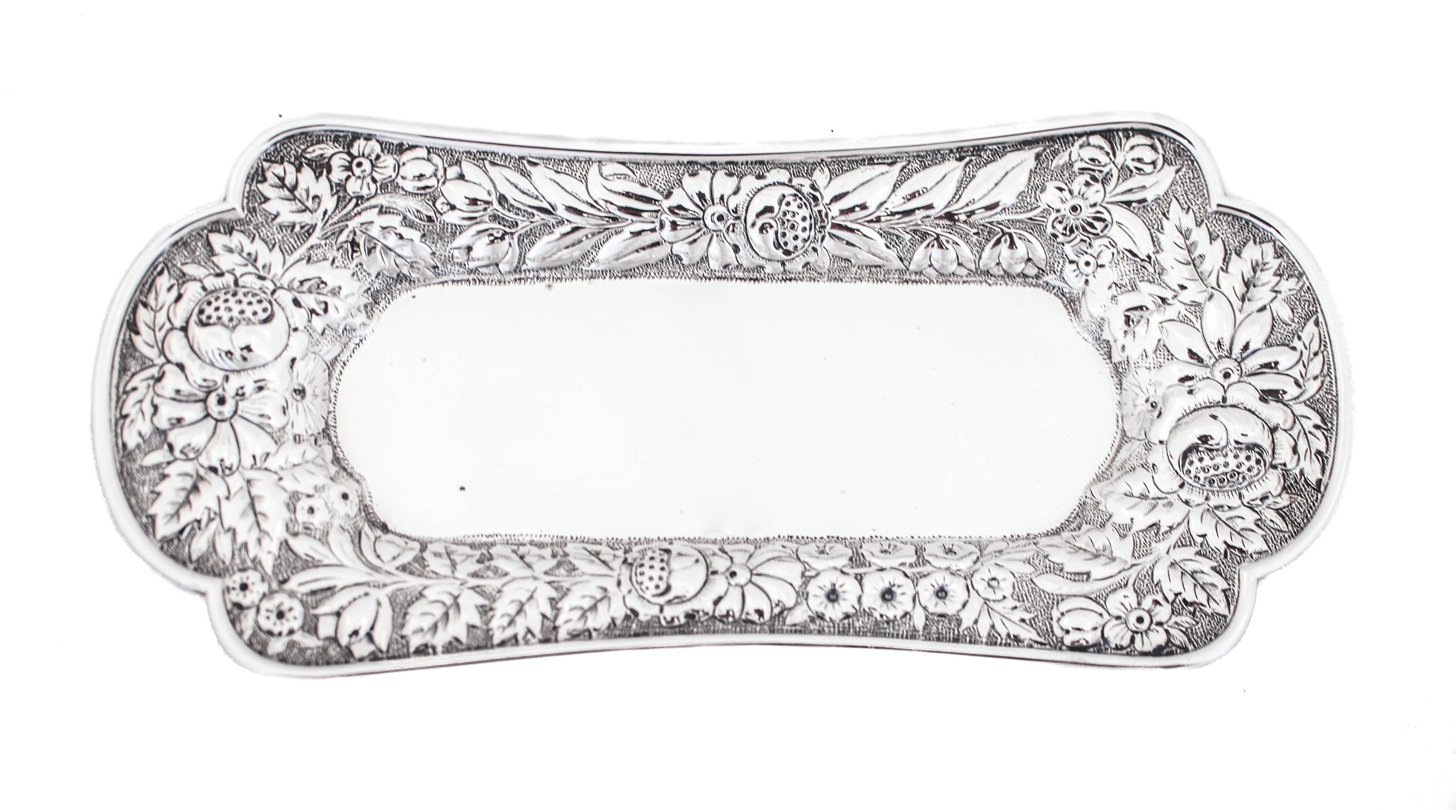 Being offered is a sterling silver antique ring tray hallmarked 1886.
It has a chased floral pattern around the edge and has a scalloped rim. The center is flat and when it’s filled you still see the beautiful work around the edge.  Perfect for