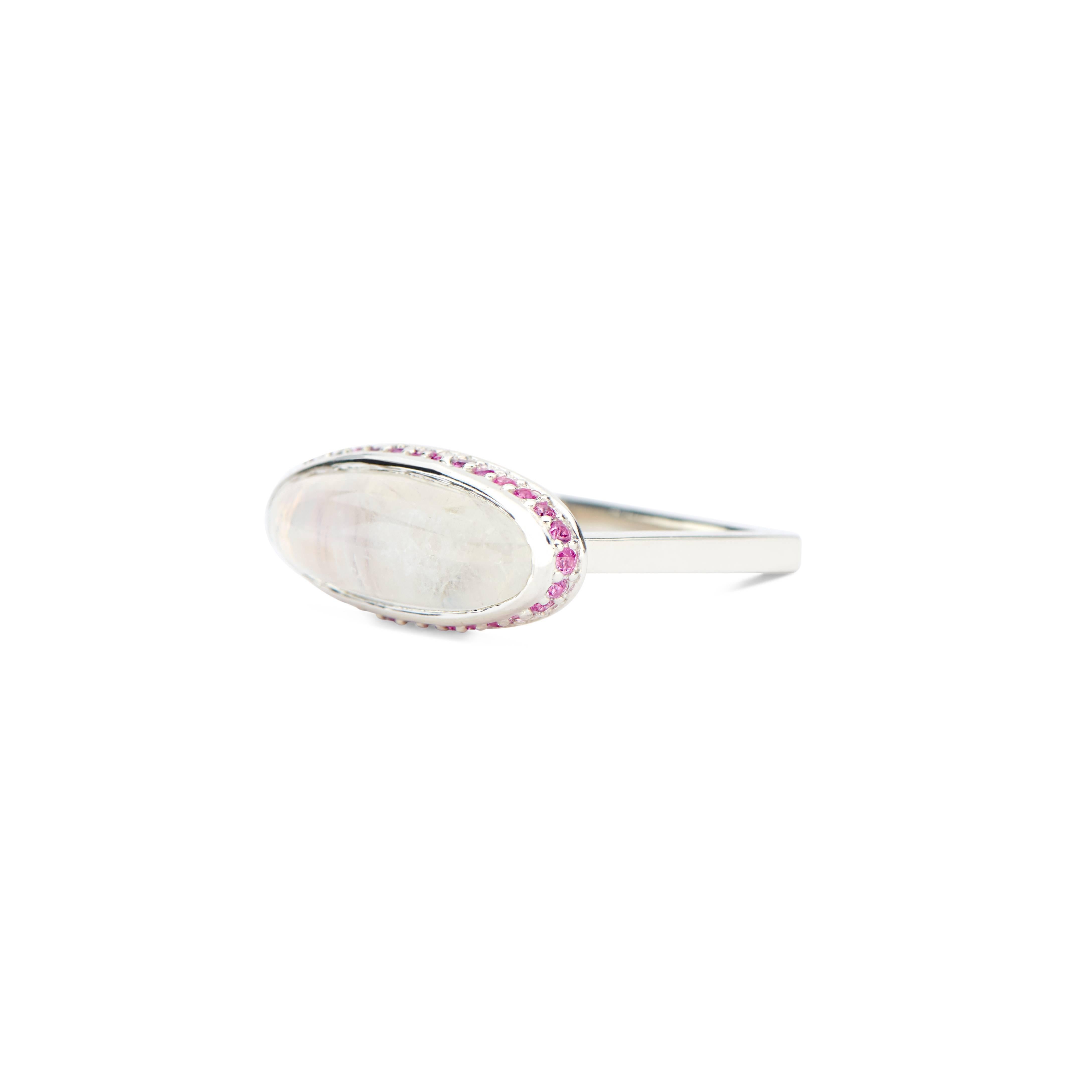 This sterling silver ring features a beautiful moonstone cabochon set in the center and surrounded by a halo of 34 light pink sapphires. It is a thoroughly contemporary style with feminine details.  The shank's unique shape is incredibly lightweight