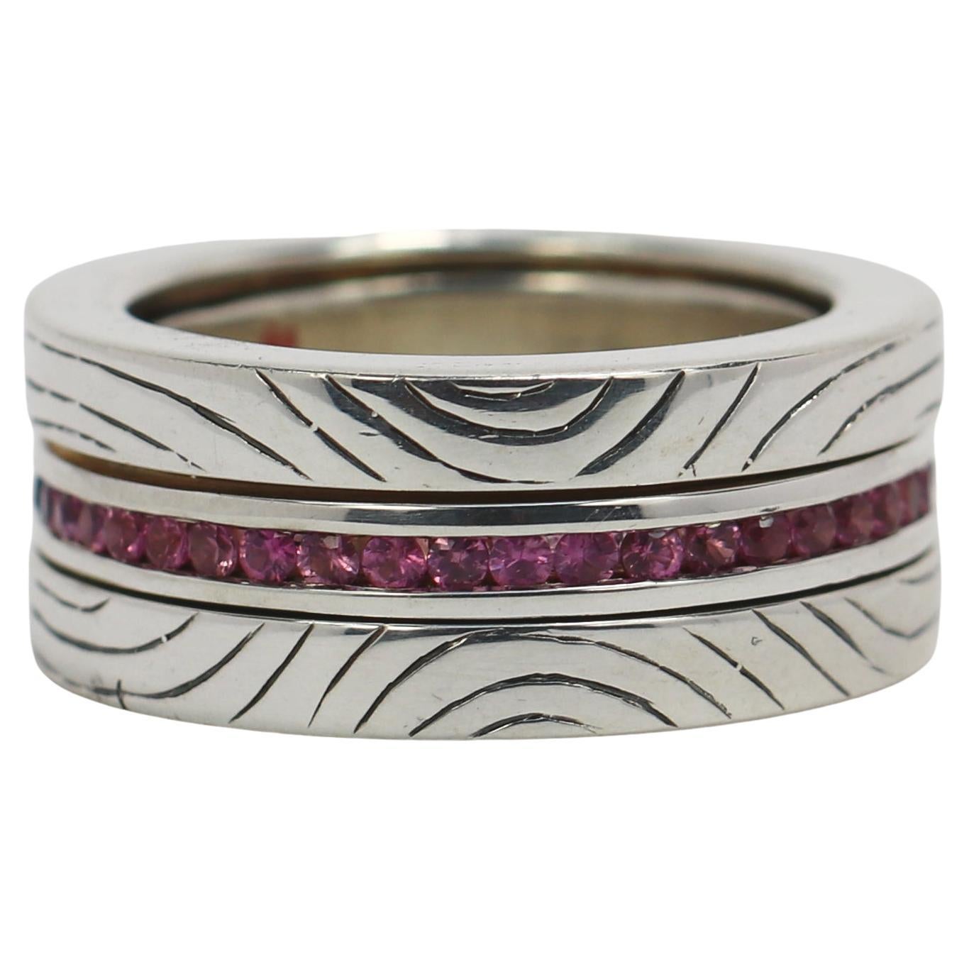 Fashioned by hand in sterling silver this 3/8-inch-wide ring has, at its center, a band of vivid blue and pink sapphires which rotates so as to add versatility to its great beauty. 
This impressive and most unusual ring fits a size 7 1/2 finger and