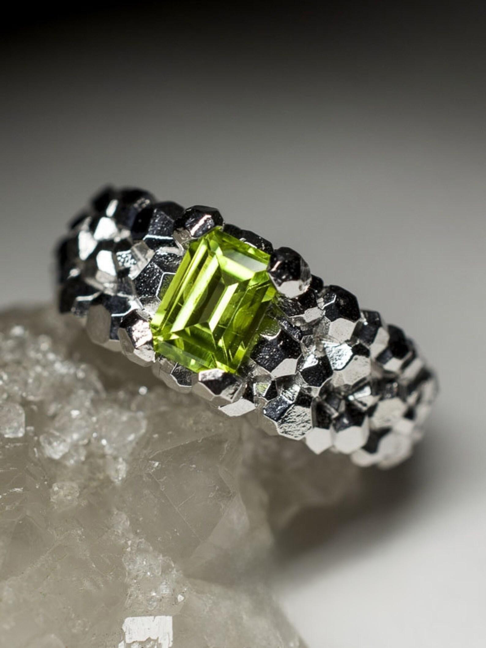 Questo elegante anello in argento sterling celebra la vivida bellezza del peridoto, noto anche come crisolito o olivina. Originaria della Cina, la gemma è presentata in un raffinato taglio ottagonale, la cui vibrante tonalità verde risplende come la