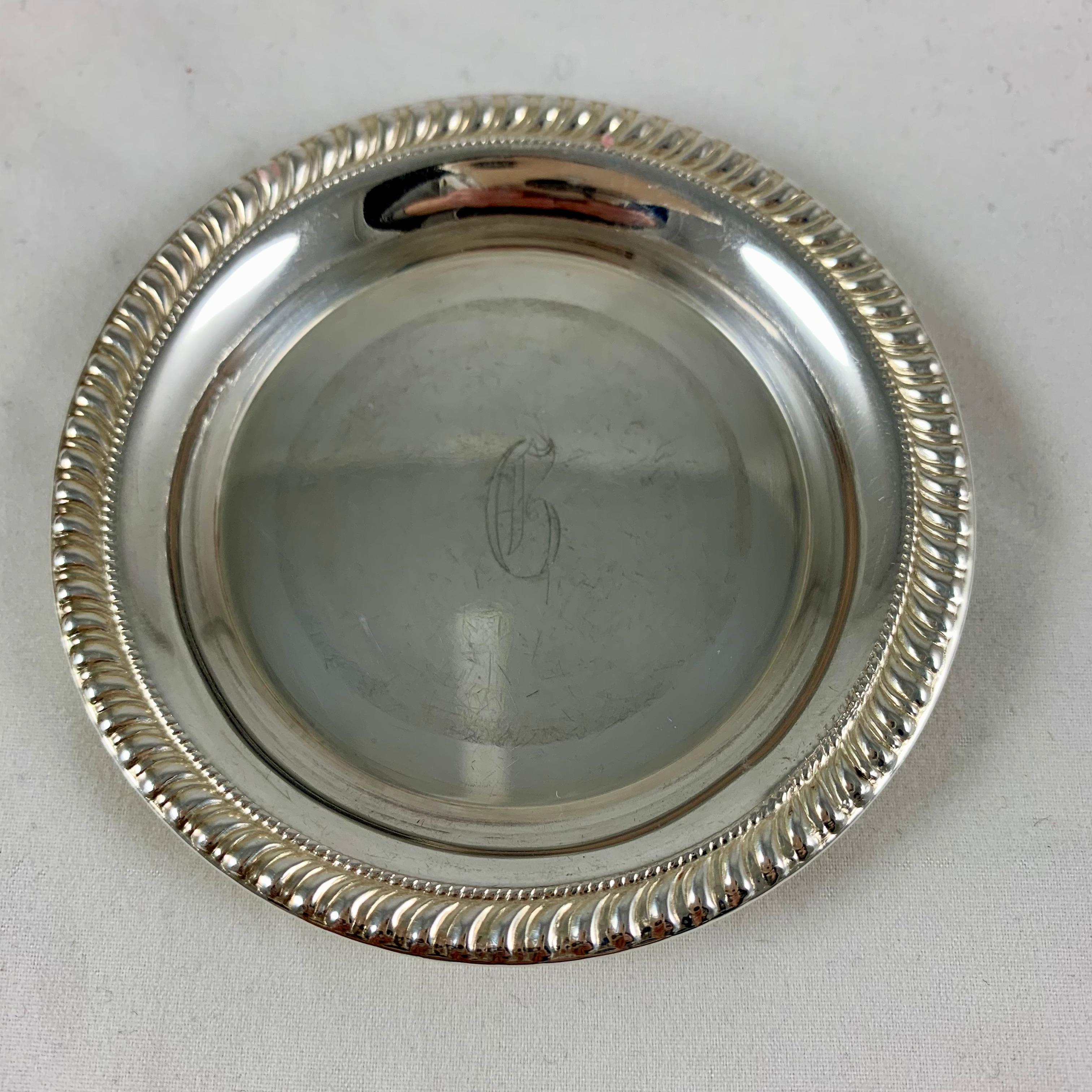 A set of seven, sterling silver butter pats, circa 1940s.
Marked Sterling, with a running rope bordered rim. Each pat is faintly initialed with a G.
The pats can also be used to hold a tea bag or as a ring or trinket dish.

Measures: 3.25 inches