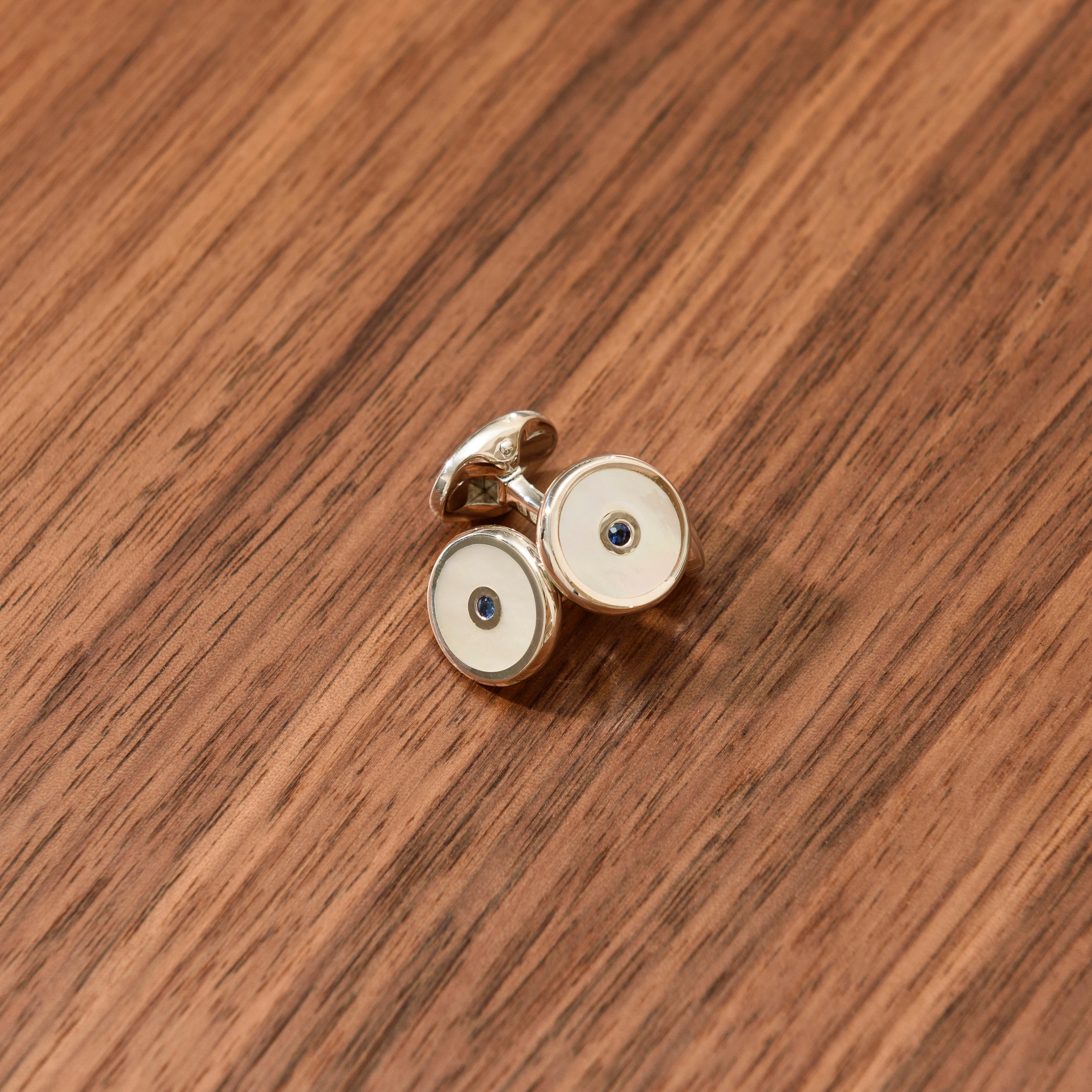 DEAKIN & FRANCIS, Piccadilly Arcade, London

These beautiful round, sterling silver cufflinks contain a beautiful hand-cut mother-of-pearl inlay with striking sapphire blue stone centre and spring link fitting.

The perfect finishing touch to any