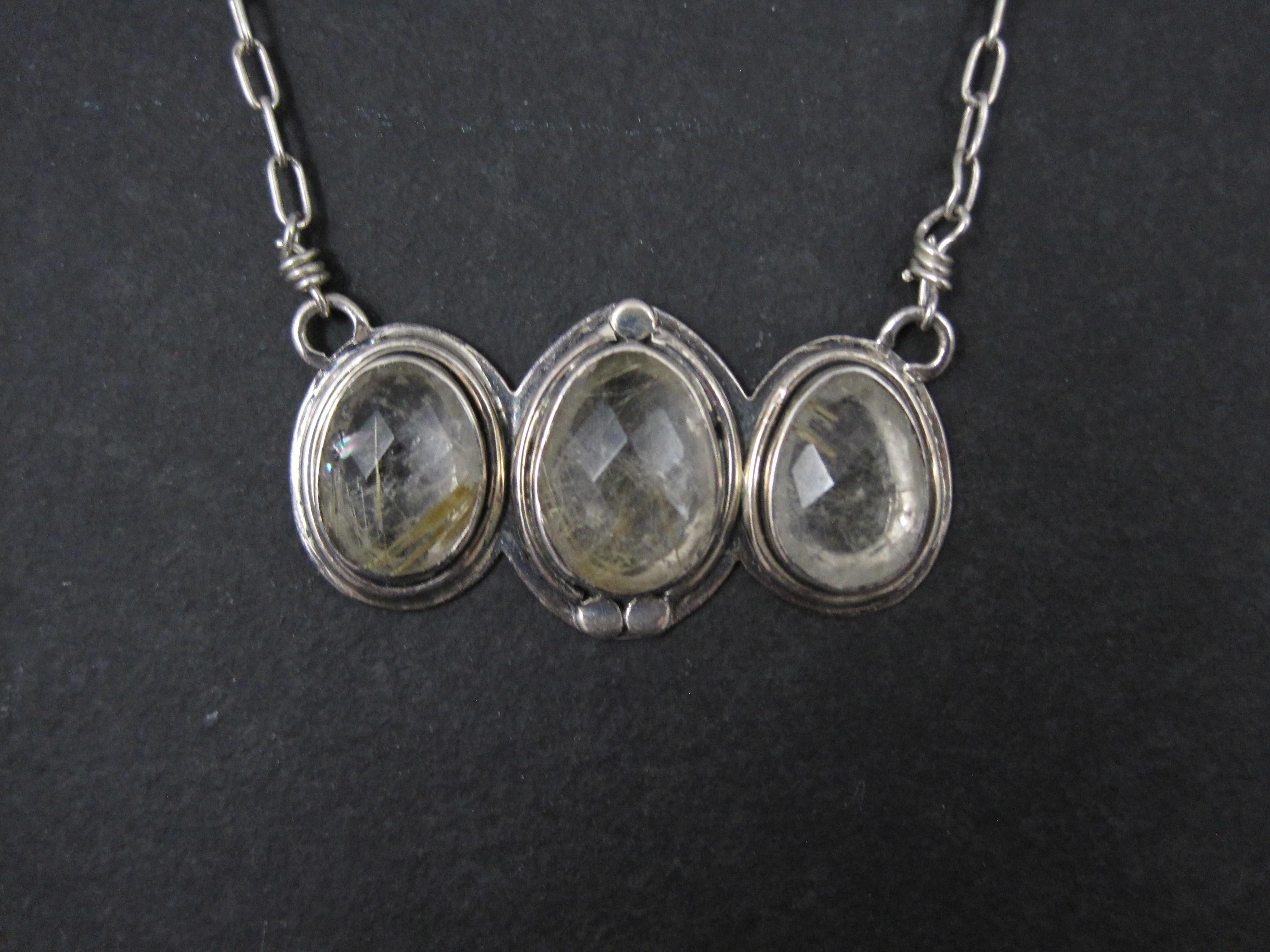 This gorgeous necklace is sterling silver. It features 3 faceted rutilated quartz gemstones.
The pendant measures 7/8 by 1 11/16 inches.
The chain measures 18 inches plus a 2 inch extender.
Weight: 13.6 grams
Marks: 925
Condition: Excellent