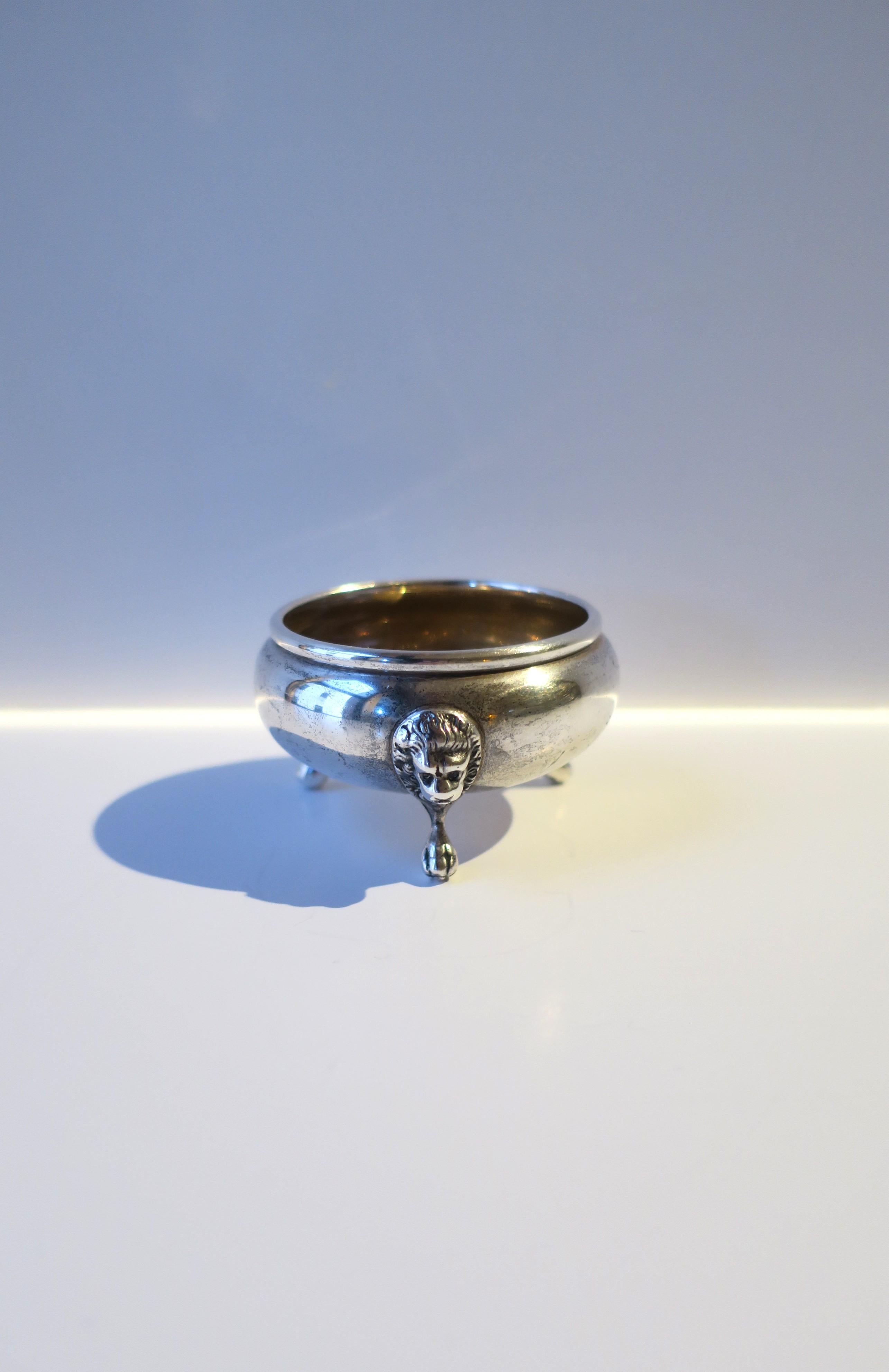 A sterling silver salt cellar with Lion head and paw feet detail, in the Empire style, circa early-20th century. Piece is a salt or pepper cellar vessel. A great piece for a dining table. Alternatively, please can be used to hold small items on a