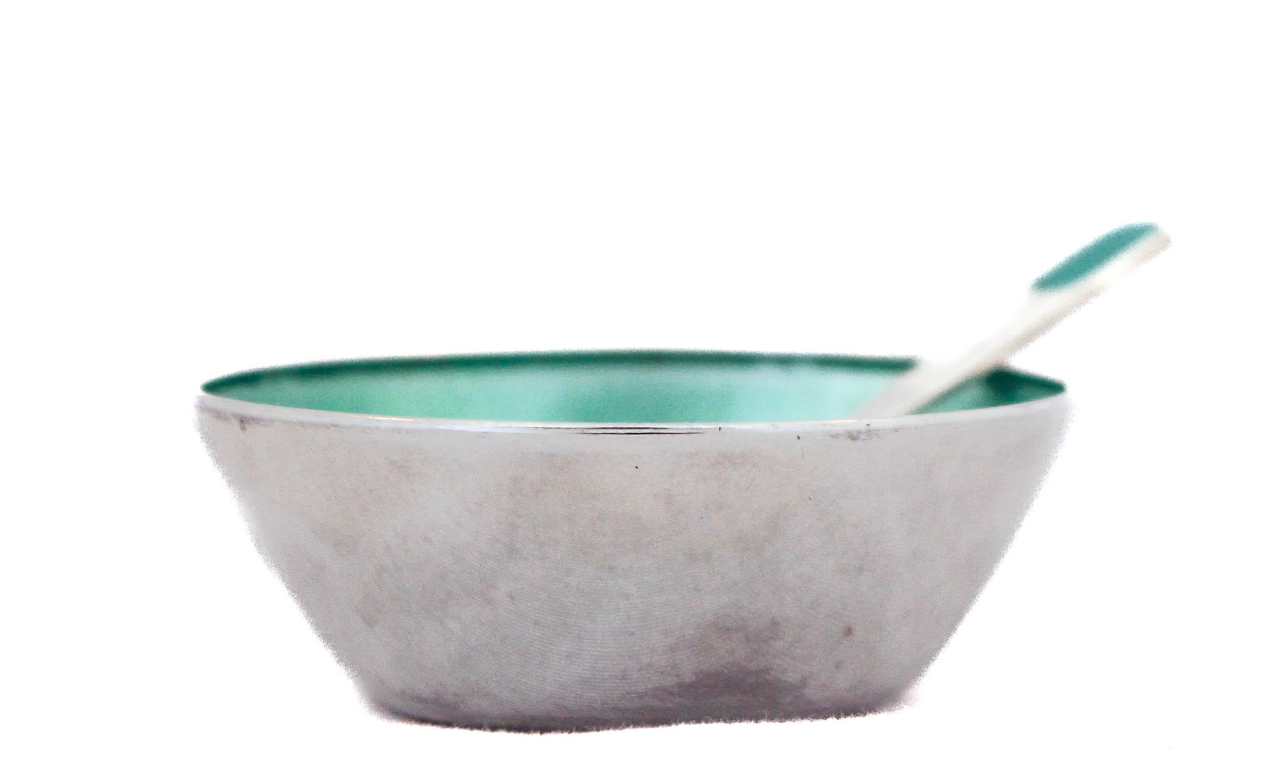 Being offered is a sterling silver salt cellar and matching spoon.  Designed and manufactured by the famous Danish silversmith David Anderson, who was known for using enamel with his silver pieces.  There is a sea-foam green  enamel on the inside of