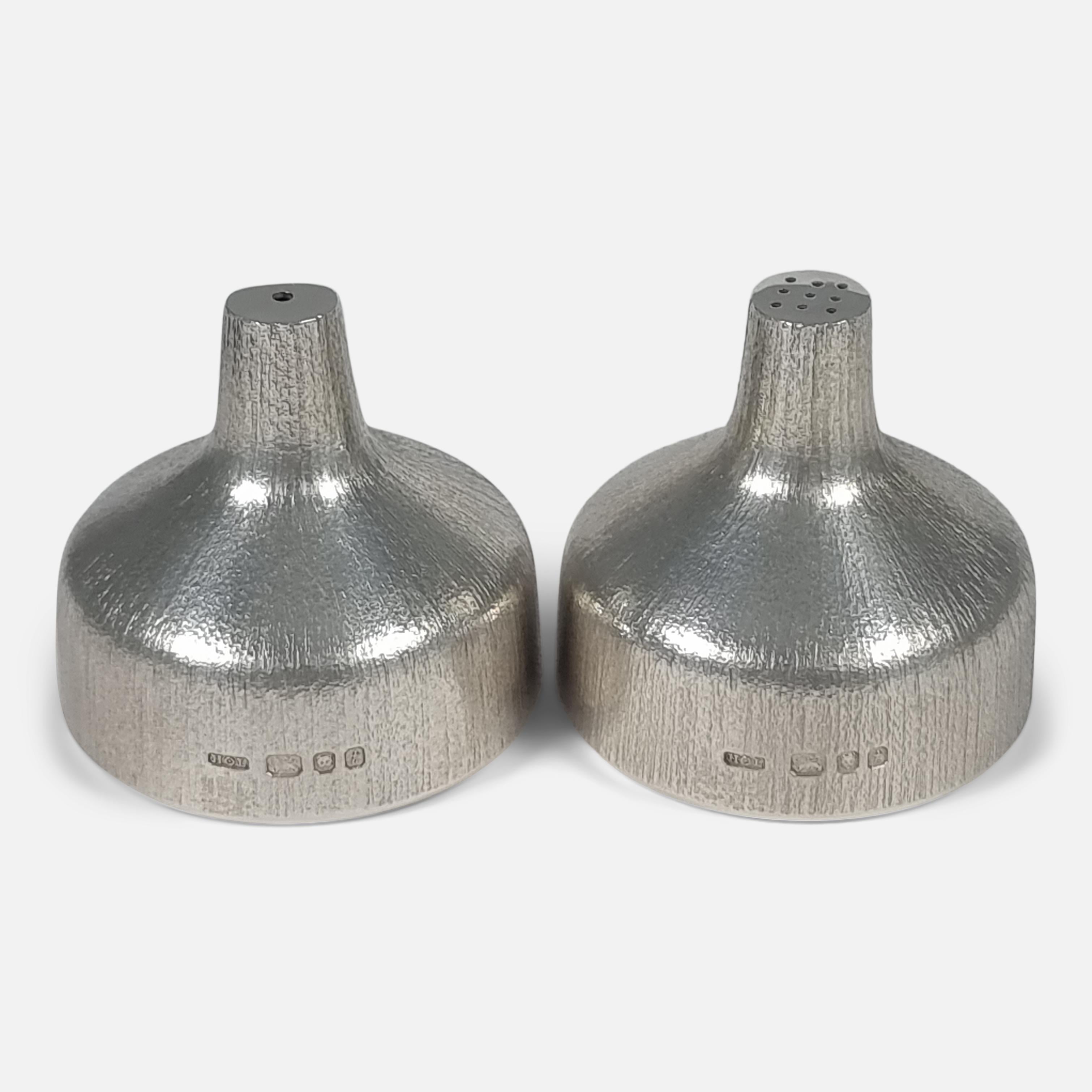 An Elizabeth II silver salt and pepper shaker set by House of Lawrian. The salt and pepper shakers are of squat tapering round form, with bark-effect decoration.

Assay: - .925 (Sterling Silver).

Period: - Late 20th Century.

Date: - 1974.

Maker:
