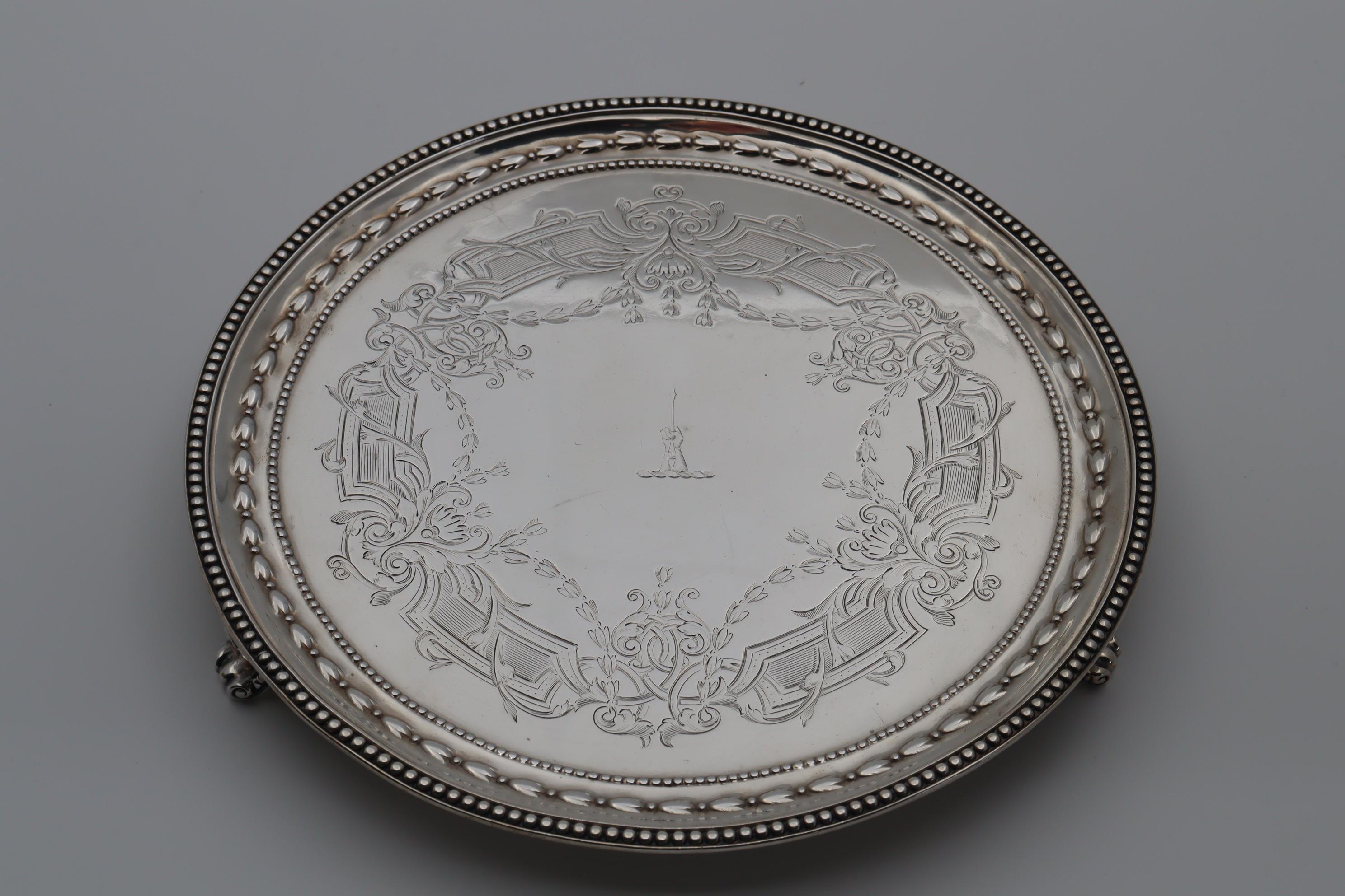 This beautifully engraved sterling silver salver by John Samuel Hunt is decorated with a line of wheat husks which runs around the rim and is contained between two beaded lines. The wheat husk is also incorporated into the very intricate and