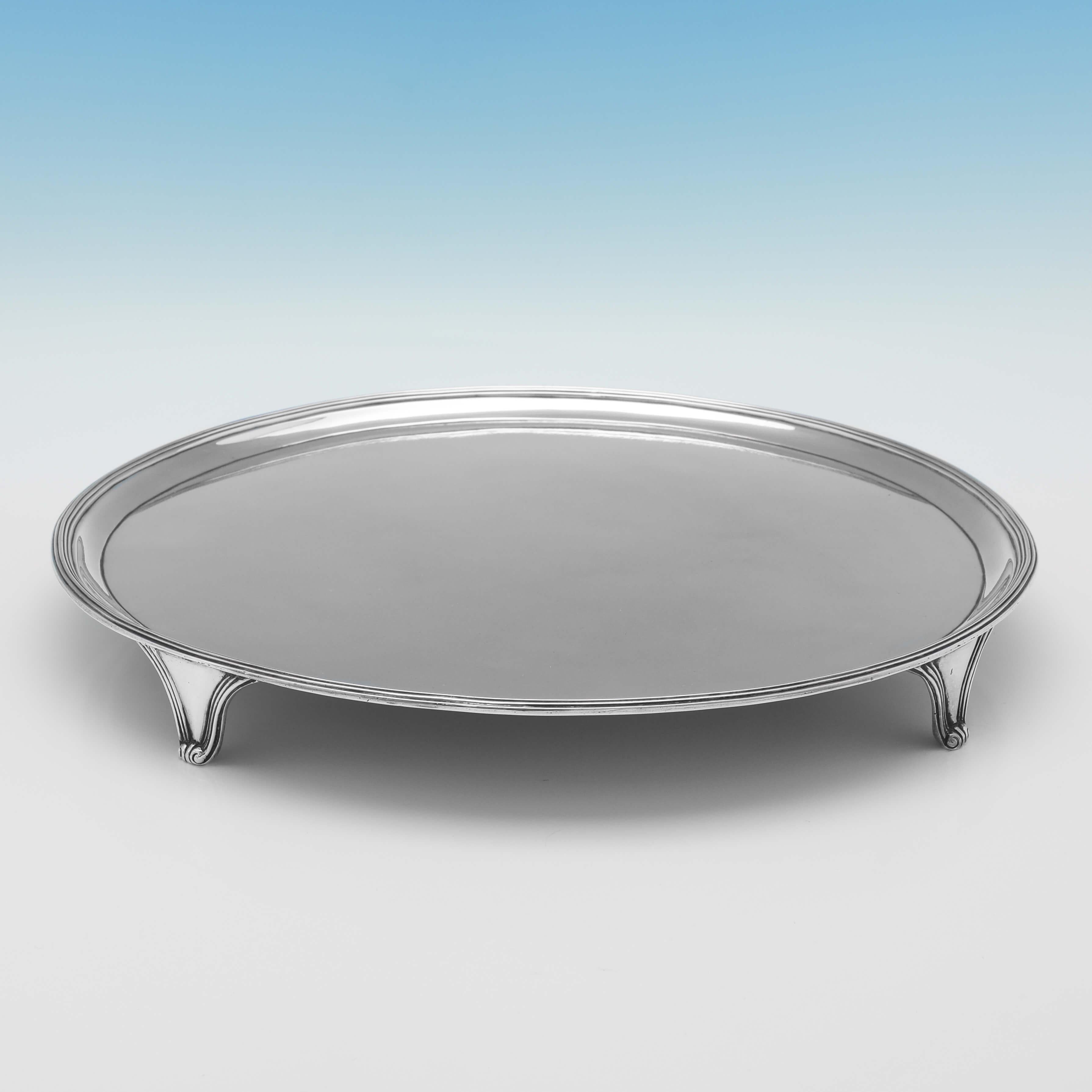 Hallmarked in London in 1792 by John Hutson, this very handsome, George III, Antique Sterling Silver Salver, is plain in style, round in shape, and features reed borders, and reed detailed feet. The salver measures 1.5
