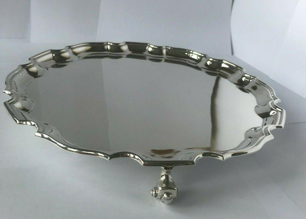 Sterling Silver Salver/Tray by Searle & Co from 1964

This beautiful tray is in excellent condition. Round with crisp and molded curvilinear rim, also called a Georgian piecrust rim. It stands on three leaf-capped volute supports. It is in the style