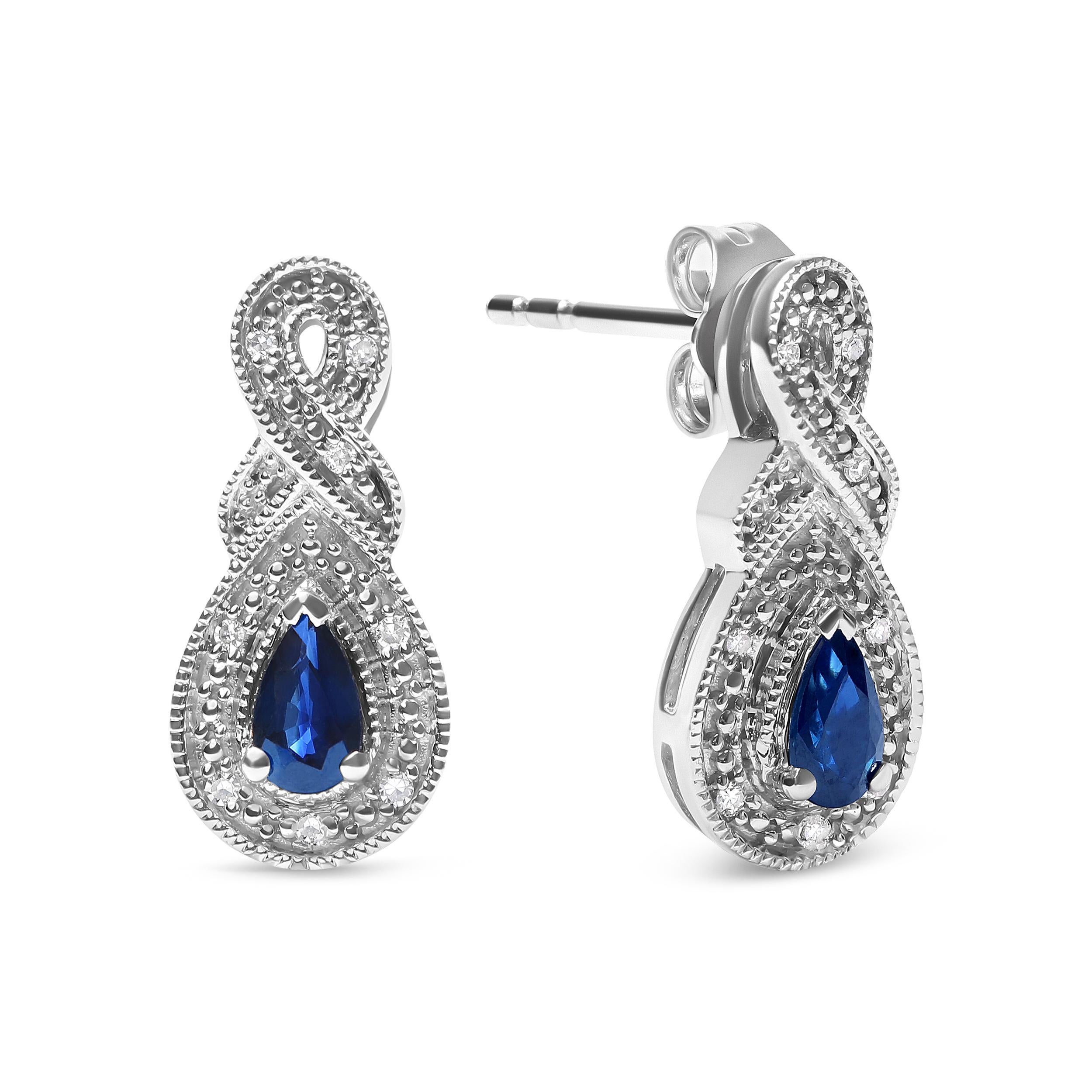 Prepare to dazzle in these stunning sapphire and diamond drop stud earrings, crafted from .925 sterling silver. Featuring two natural pear-shaped blue sapphires, each measuring 4.5 x 3mm, and accented by 14 round-cut natural diamonds, these earrings