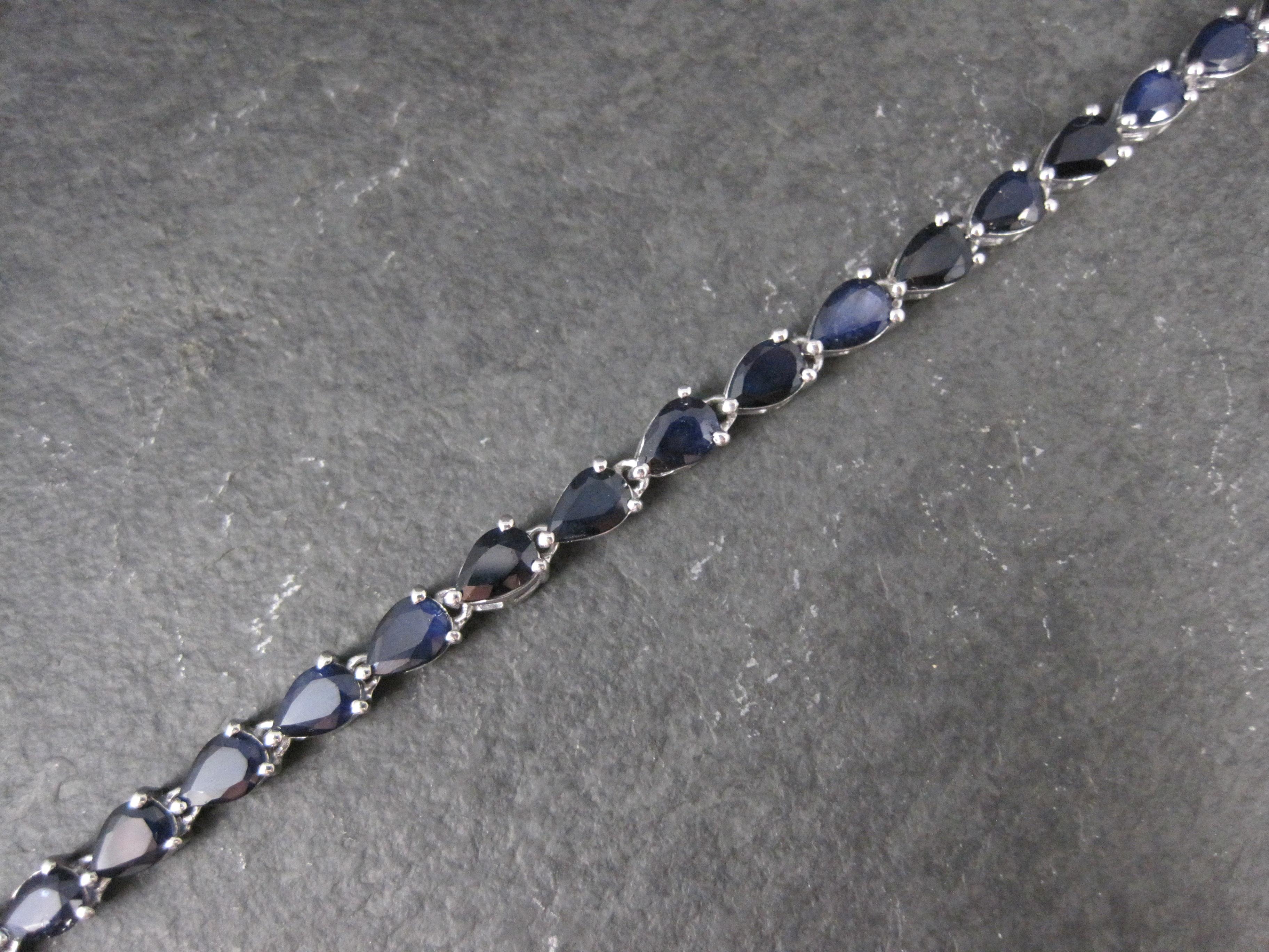 This gorgeous estate bracelet is sterling silver.
It features an estimated 10.8 carats in 27 pear cut 4x6mm sapphire gemstones.

Measurements: 3/16 of an inch wide, 7 1/2 wearable inches
Weight: 9.7 grams

Marks: 925, Chuck Clemency's STS