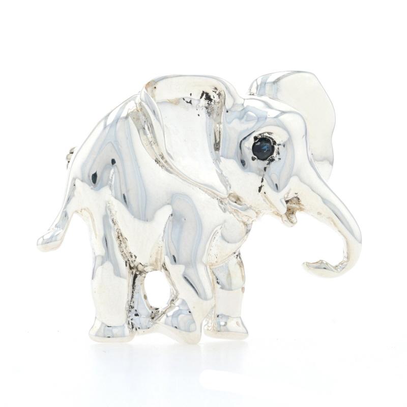 Metal Content: Sterling Silver

Stone Information
Natural Sapphire
Treatment: Heating
Carat: .04ct
Cut: Round
Color: Blue

Style: Brooch/Pendant 
Fastening Type: Hinged Pin and Whale Tail Bullet Clasp
Theme: Walking Elephant,