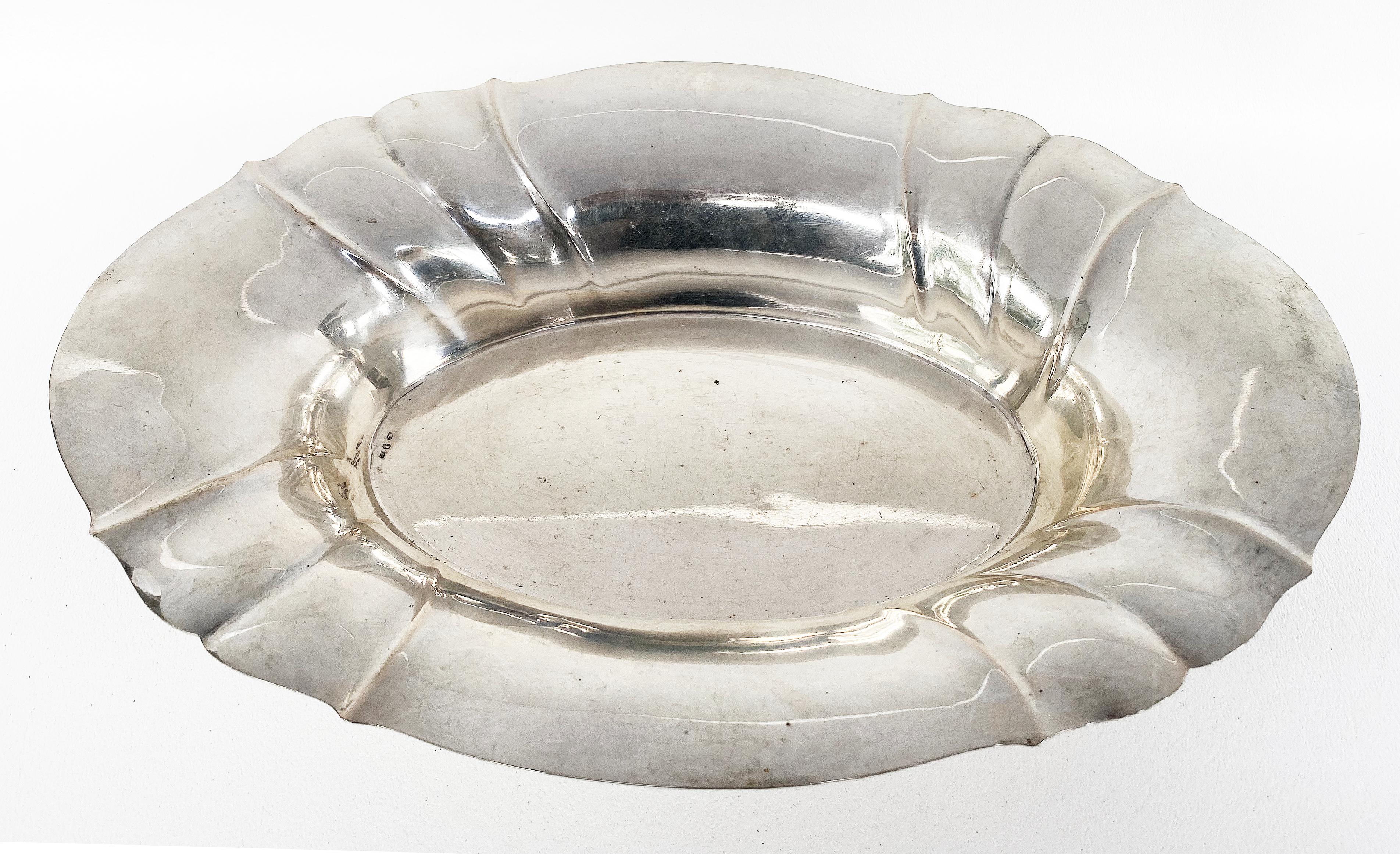 Sterling silver scalloped bread basket / tray with hallmarks on the underside

Offered for sale is a vintage oval form sterling silver bread basket or small serving tray that is marked with hallmarks on the underside as pictured. The top edge is