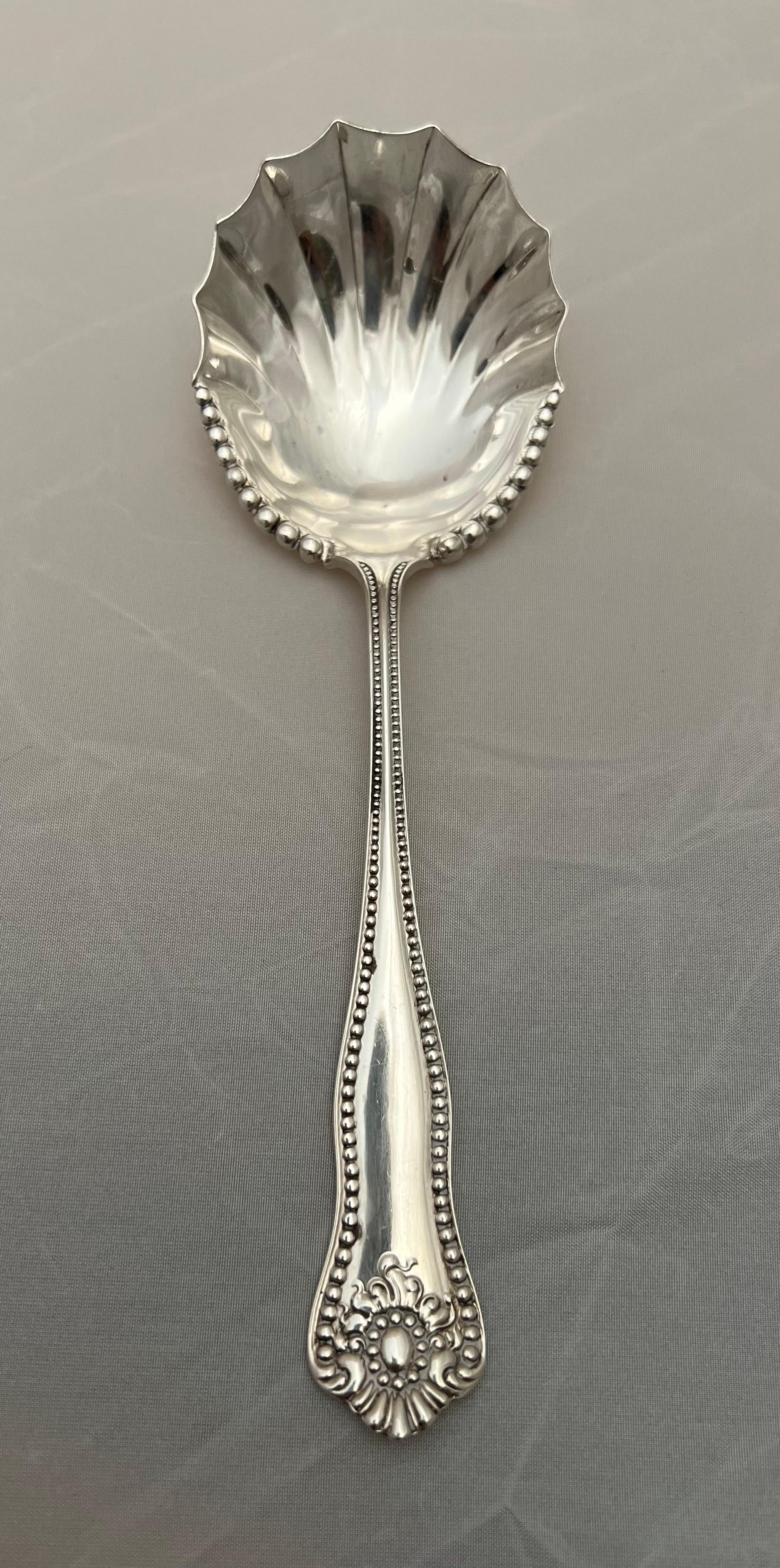Sterling silver scalloped shaped serving spoon. Sterling is stamped on the back of the spoon as depicted in photos.