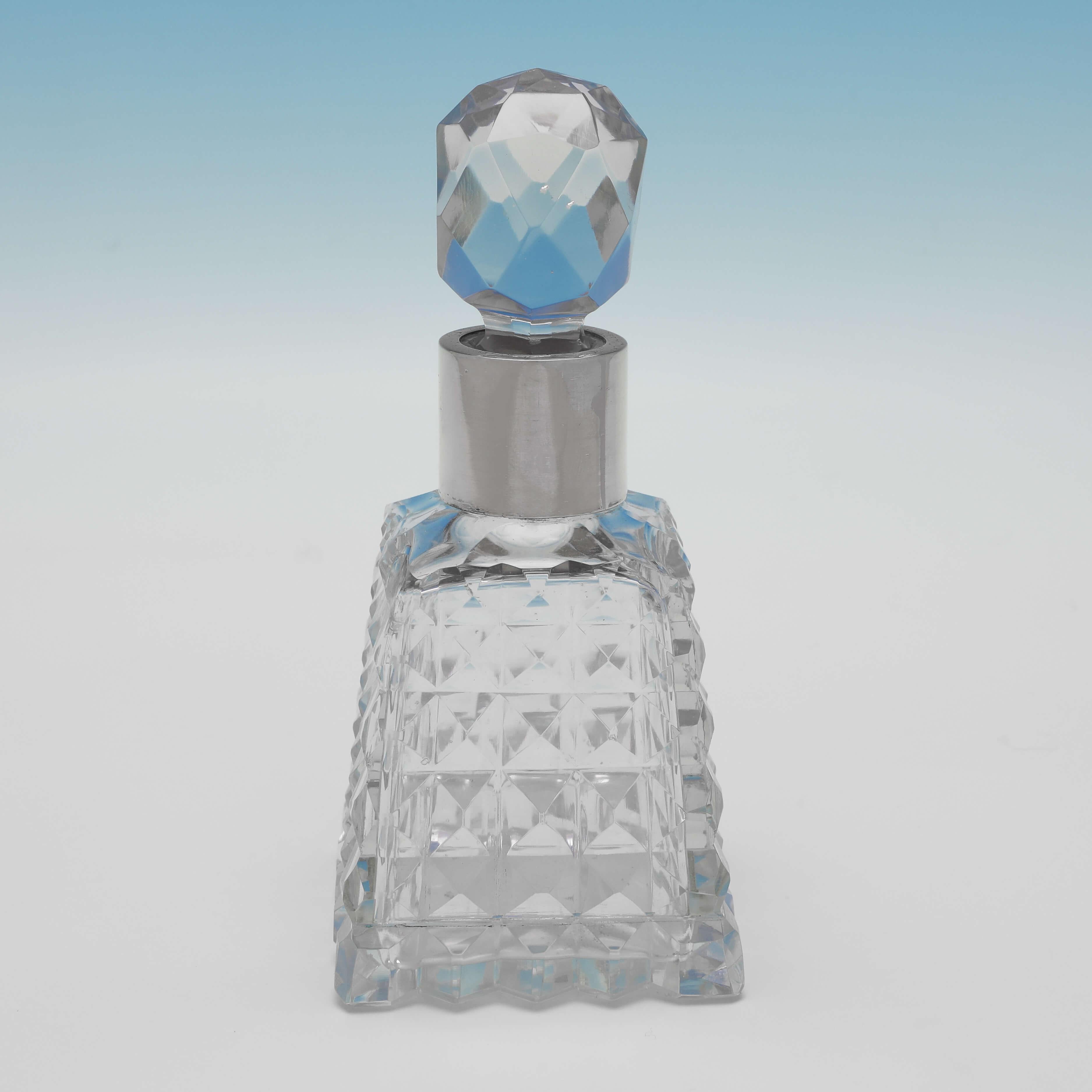 Hallmarked in London in 1893, this stylish, antique sterling silver scent bottle, features a hobnail cut glass body, a faceted stopper, and a plain silver collar. The scent bottle measures 5.5