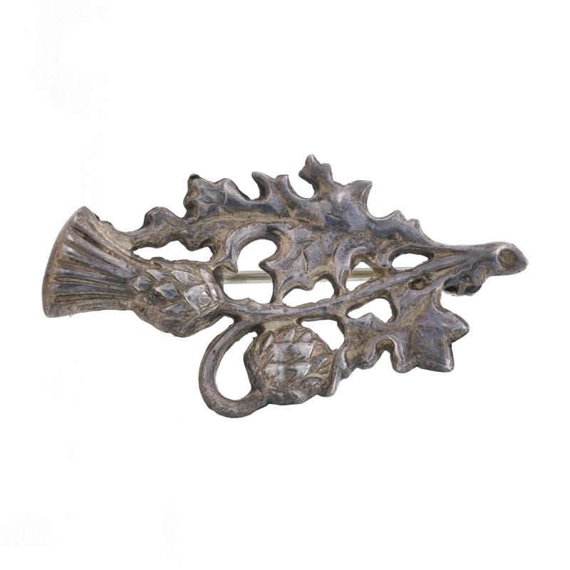 Date: 1912

Metal Content: Sterling Silver

Style: Brooch
Fastening Type: Hinged Pin and Whale Tail Clasp
Theme: Scottish Thistle

Measurements

Tall: 13/16