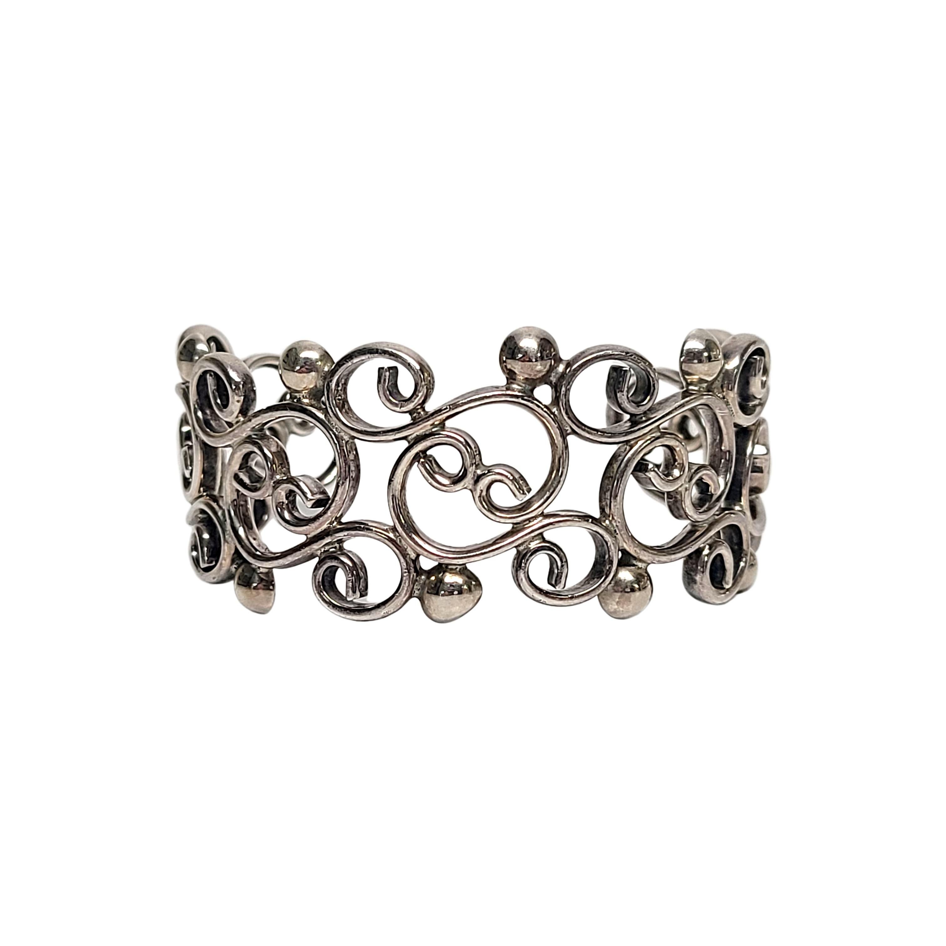 Sterling silver scroll design cuff bracelet.

Open work scrolls with round bead-like edges.

Measures approx 5 1/4