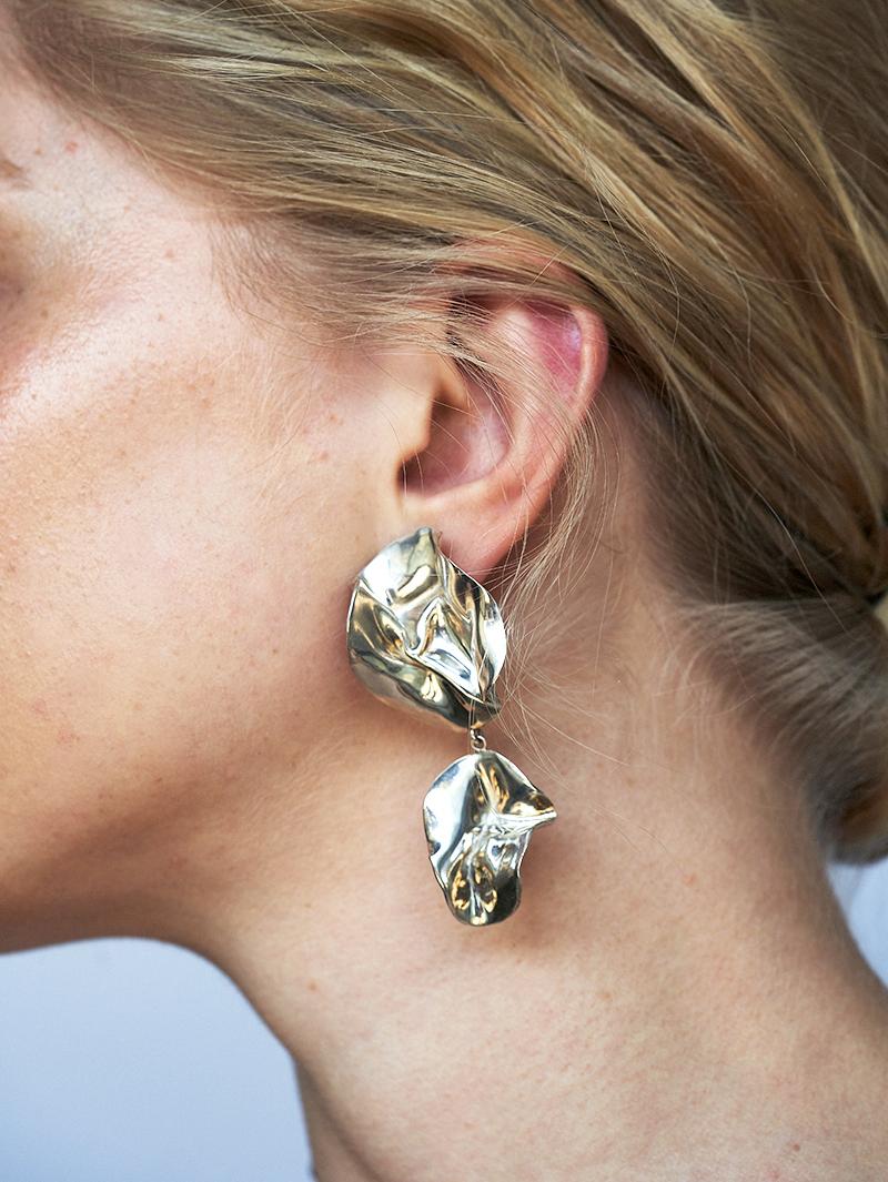 The Fold Earrings are sculptural folded earrings that have been molded by hand. Their intricate folds are highlighted by the high-polished Mirror Finish. Wear them day or night with your hair tucked back to let them shine. 

Sterling silver