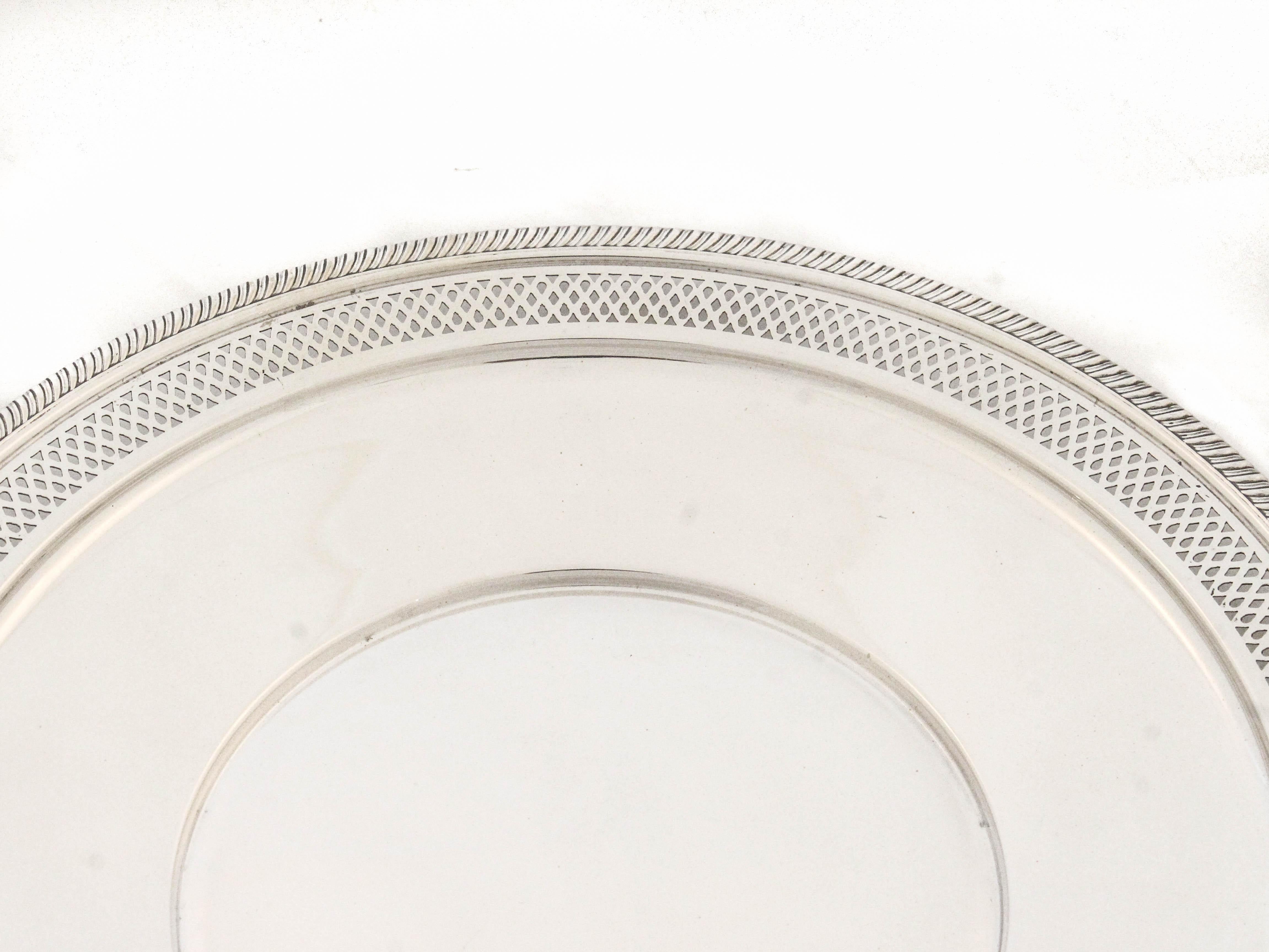 A classic 10-inch round sterling silver plate crafted by Fisher Brothers, a respected American silversmith known for elegant and timeless tableware. This piece features a finely executed reticulated design encircling the border, allowing light to