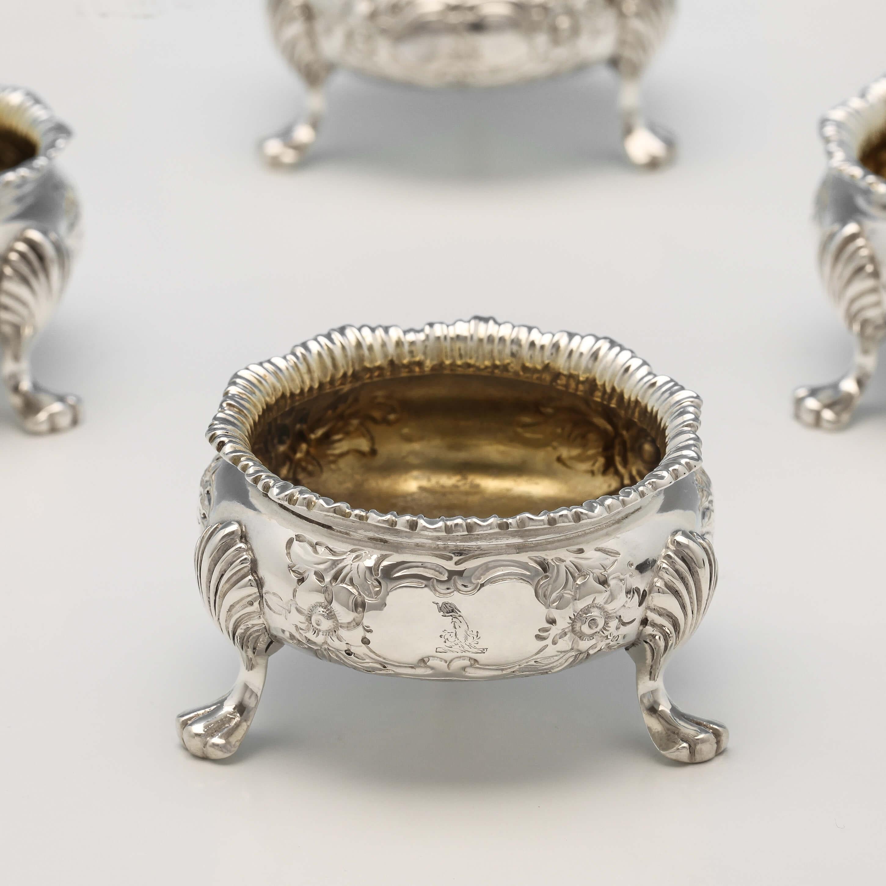 Hallmarked in London in 1892 by Charles Stuart Harris, this lovely set of 10 antique, Victorian, sterling silver salt cellars, are in the cauldron style with pretty floral chasing, paw feet, and gilt interiors. Each salt cellar measures 1.25