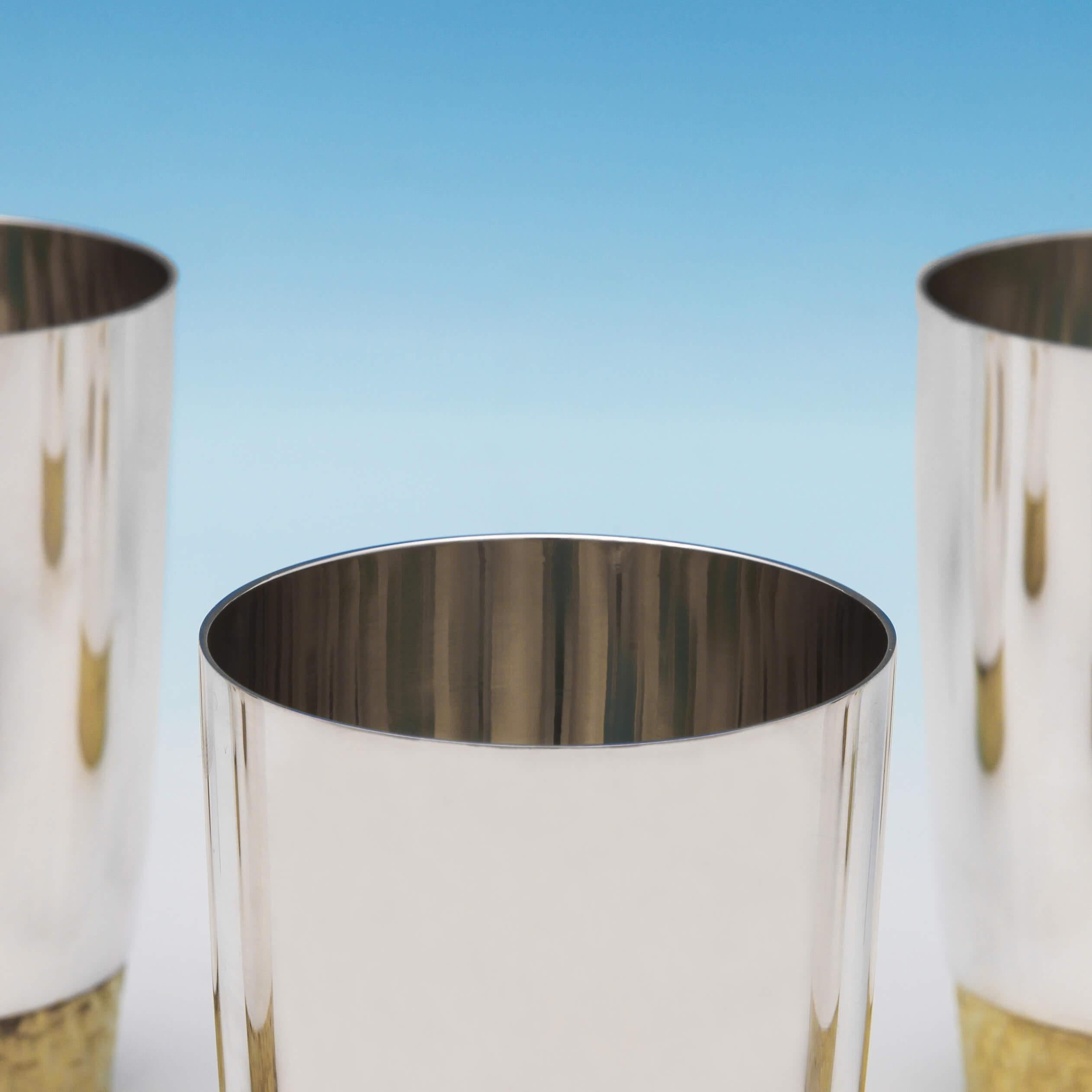 Hallmarked in London, 1972 by Stuart Devlin, this outstanding, Elizabeth II, set of 8 sterling silver beakers are typical of his work, with plain bodies and gilt bark effect bases. 

Each beaker measures 4.5