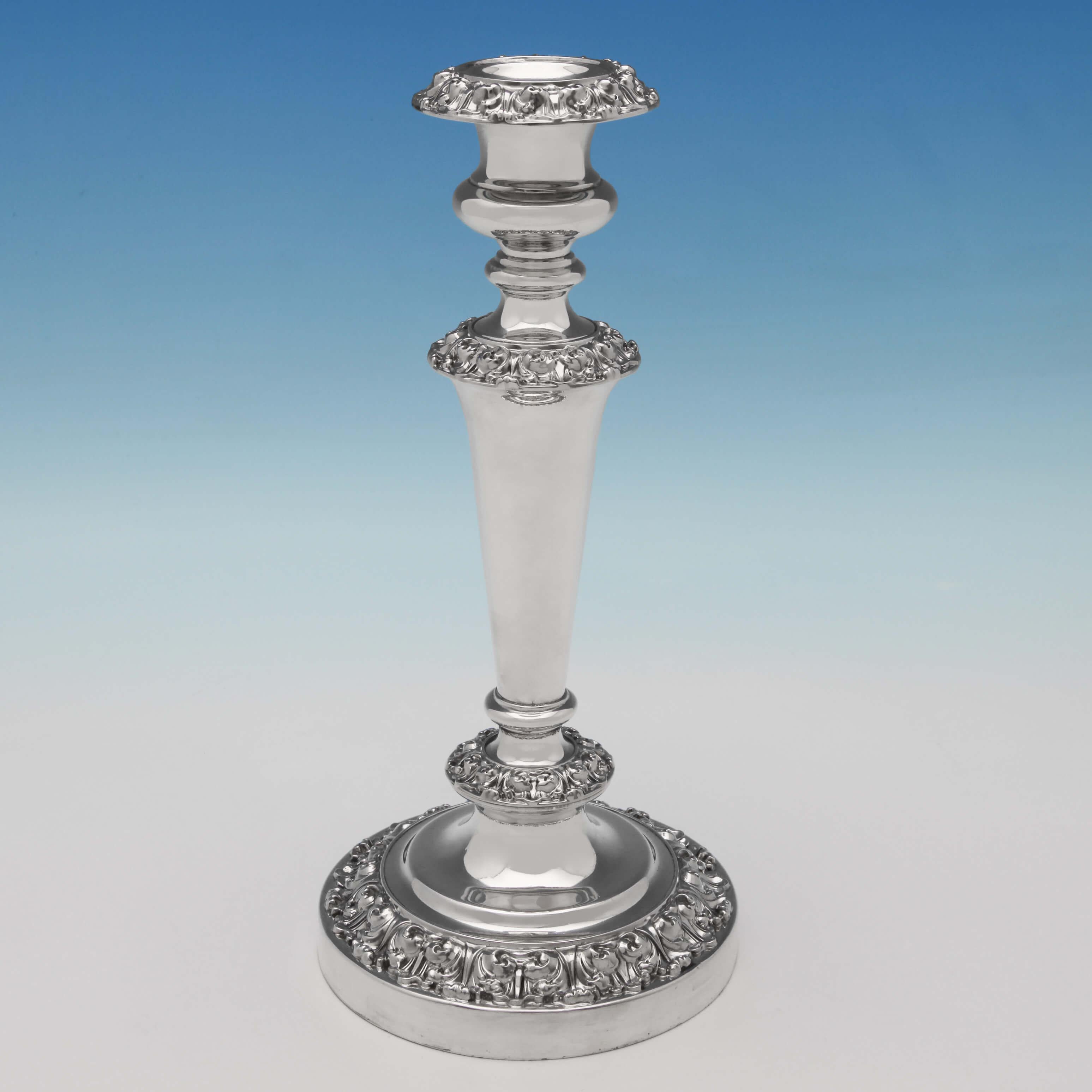 Hallmarked in Sheffield in 1828 by Waterhouse, Hatfield & Co., this attractive, ornate, George IV, antique sterling silver set of four candlesticks, feature acanthus decoration around the bases, the top of the columns and on the removable sconces,
