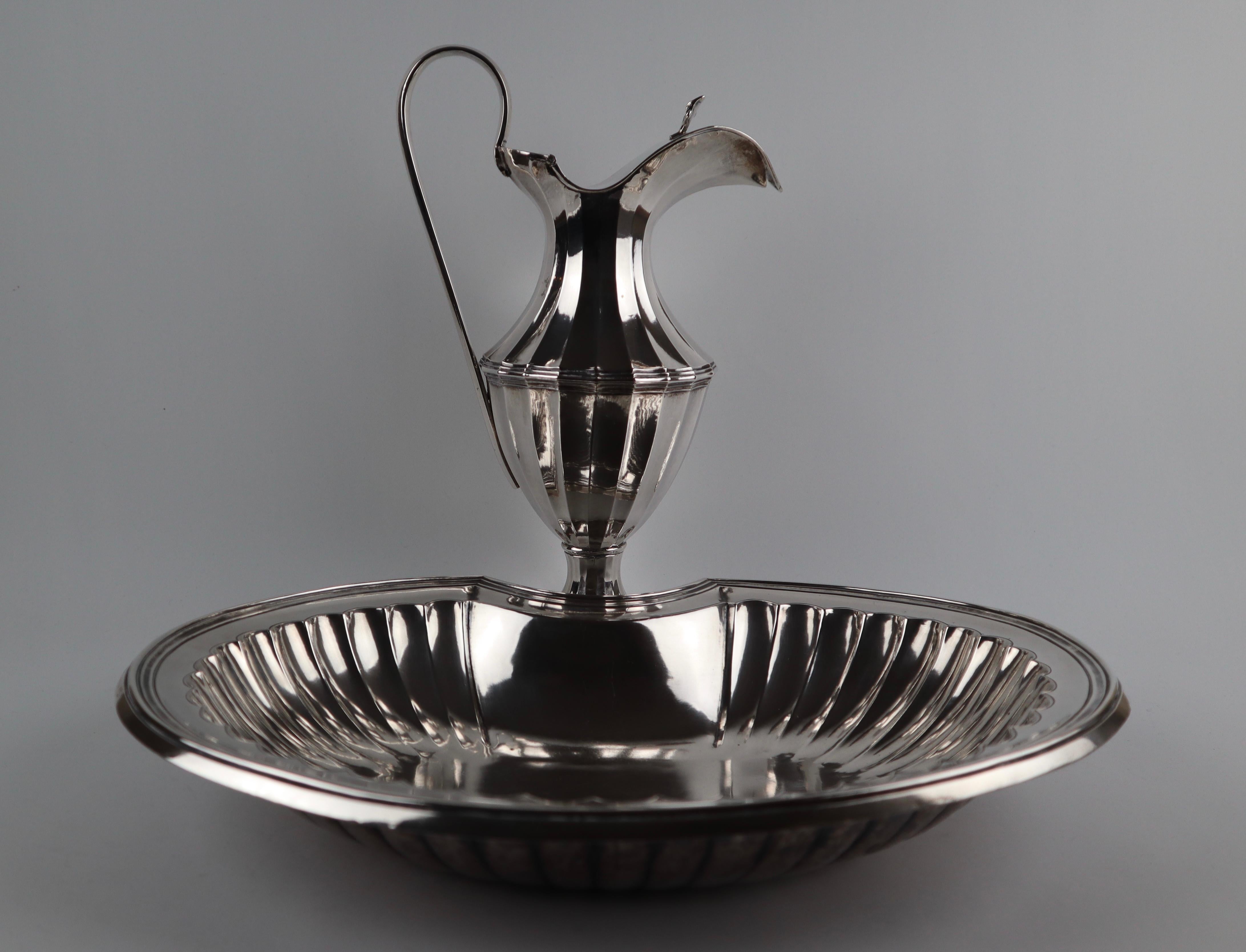 A magnificent 18th century antique hammered silver shaving bowl and jug with hinged lid.
Both bowl and jug have gadroon detailing to the main body.


Hallmarked for Porto, Portugal 1799
Makers mark AMR for António Moreira da