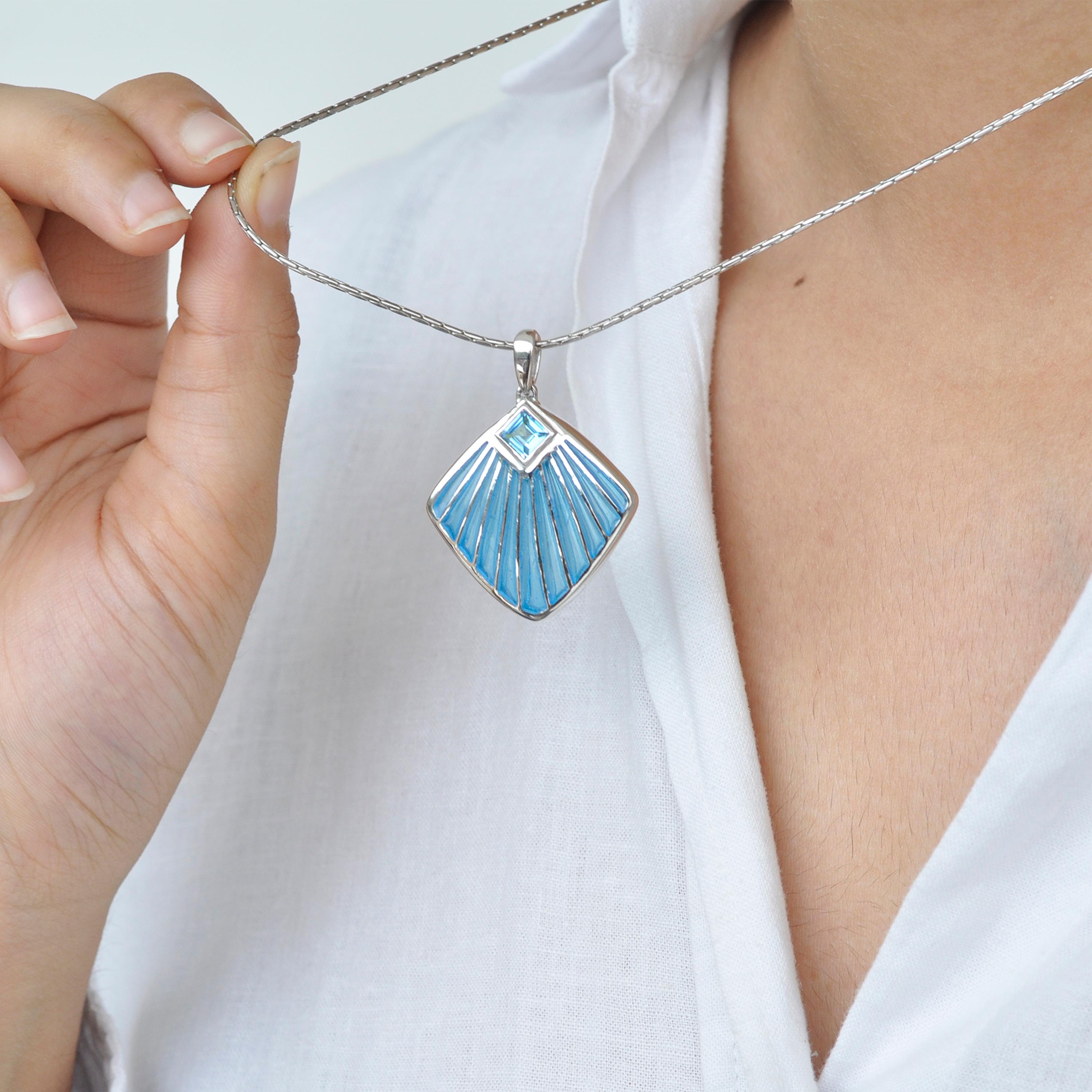 Dieser atemberaubende Blue Shell-Anhänger aus Sterlingsilber mit türkisblauer Plique-à-jour-Emaillierung ist mit einem blauen Topas aus dem Labor verziert. Der Anhänger hat an der Oberseite eine Schlaufe, durch die eine Kette leicht hindurchgeführt