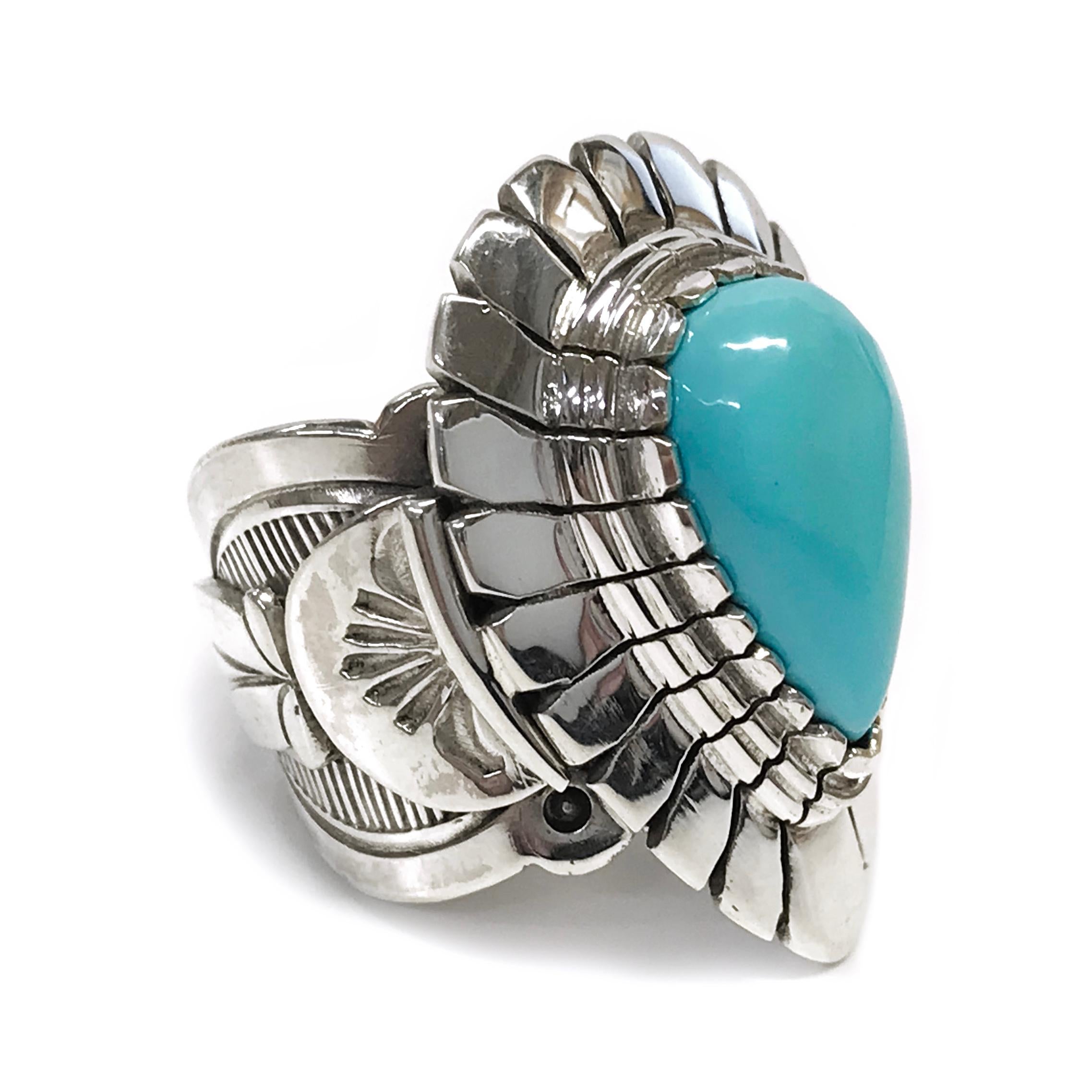 Handcrafted from sterling silver by jewelry maker, Ray Winner. This beautiful ring features a pear-shape natural Sleeping Beauty Turquoise cabochon set in a fabulous wide Native American-inspired design band and bezel. The ring measures 29.5mm high