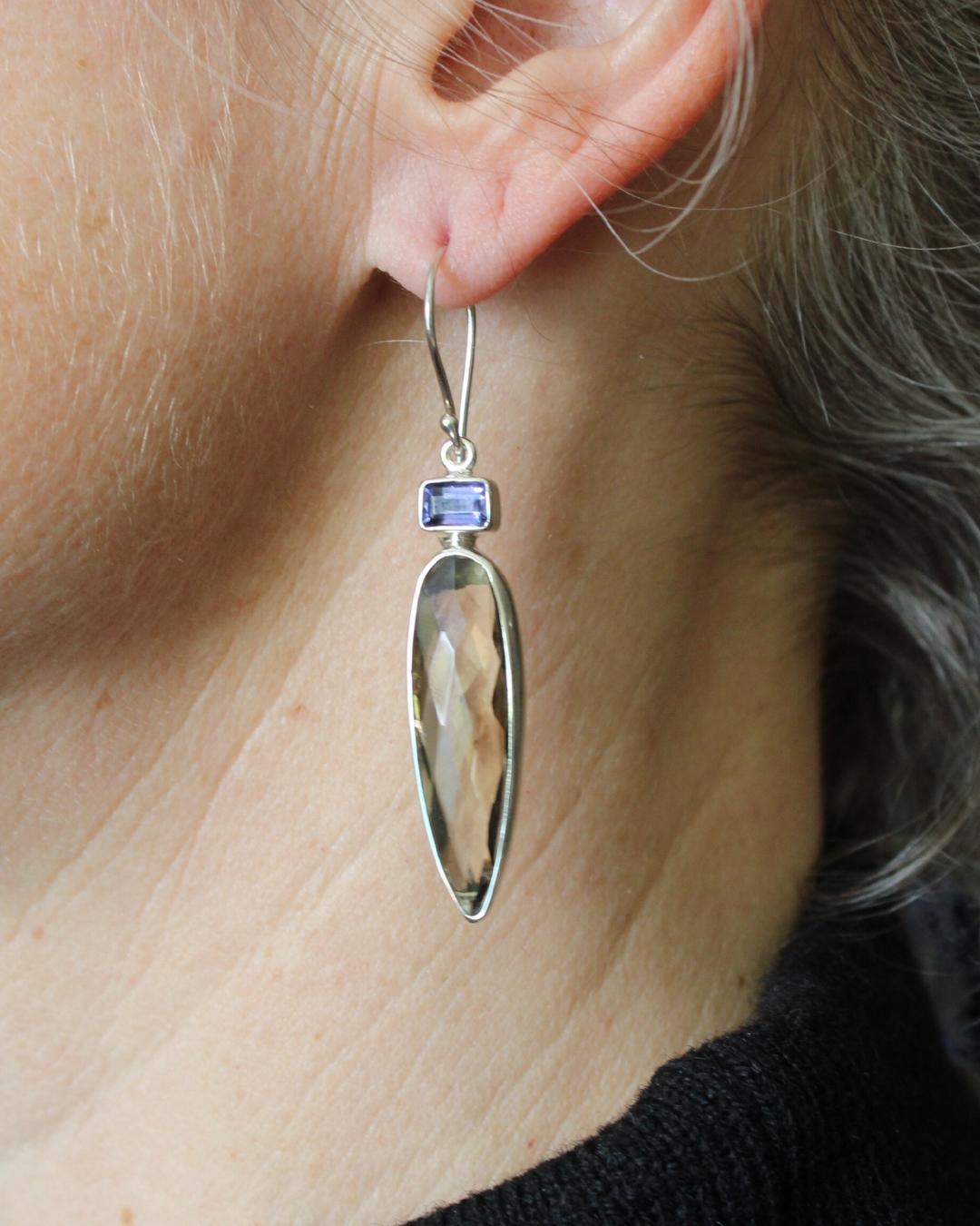 These elegant earrings feature teardrop faceted smoky quartz and emerald cut iolite set in sterling silver. The backs of the earrings are stamped with 925 and our name, Tika. We collaborate with a master silversmith in Java, in the heart of the