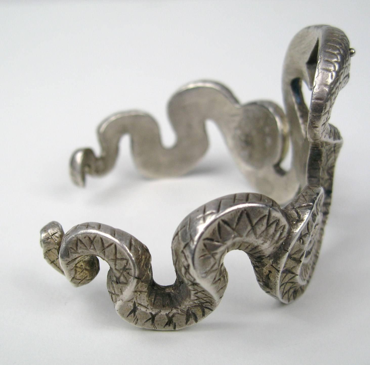 A large Sterling Silver Cuff Bracelet made up of two snakes headed from battle..Face to Face, ready to strike. This is a very cool bracelet. Hallmarked sterling silver inside the cuff.. 41 mm or 1.65 in at widest. The inner circumference is 7 in and