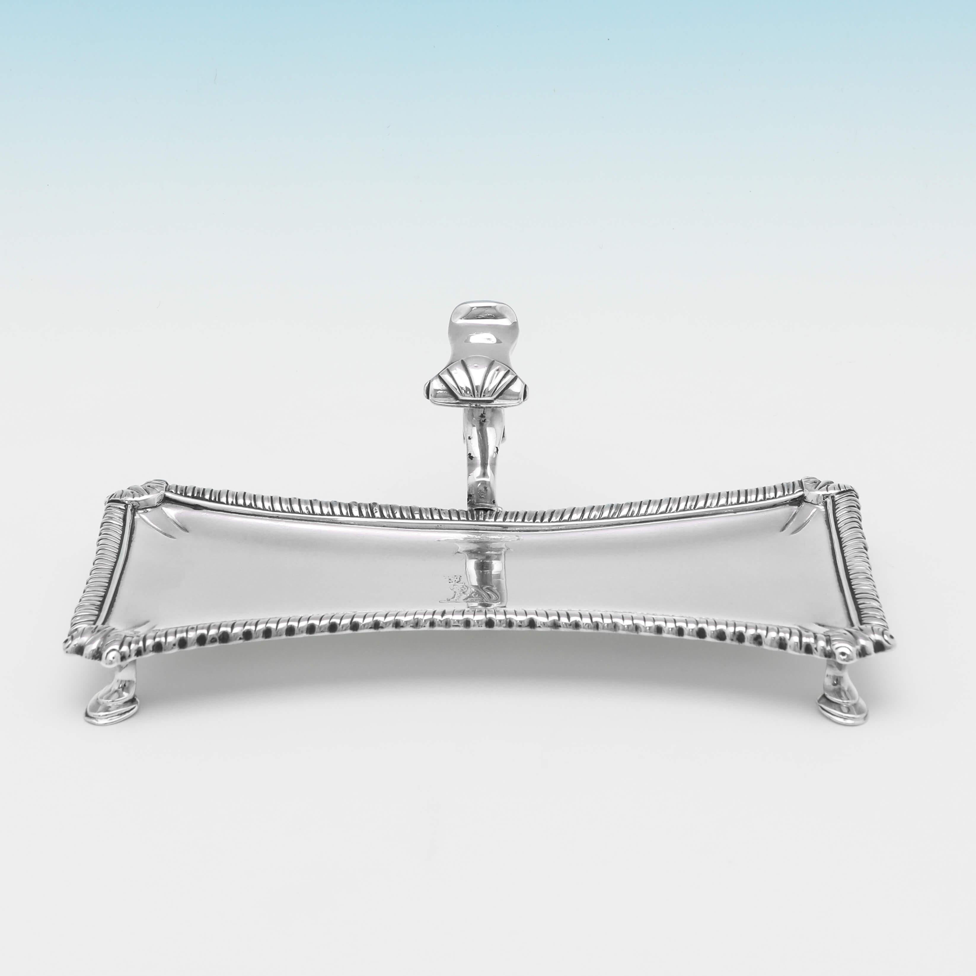 Hallmarked in London in 1765 by William Cafe, this very handsome, George III, antique sterling silver snuffer tray, would make an ideal pen tray, standing on four hoof feet, and featuring shell and gadroon borders, an engraved crest to the centre,